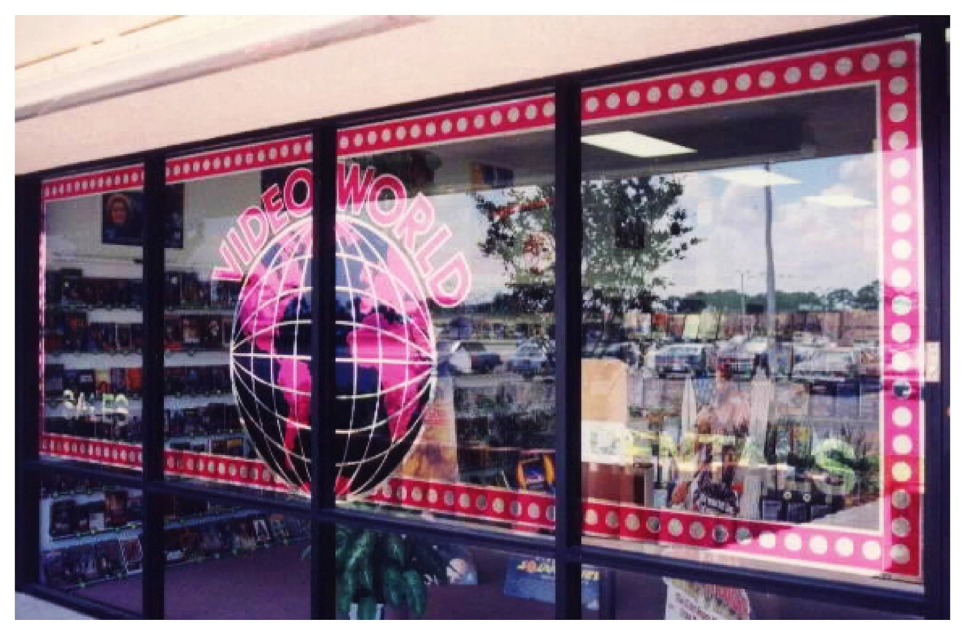 Video store exterior with 'Video World' sign and globe graphic on window colored window film