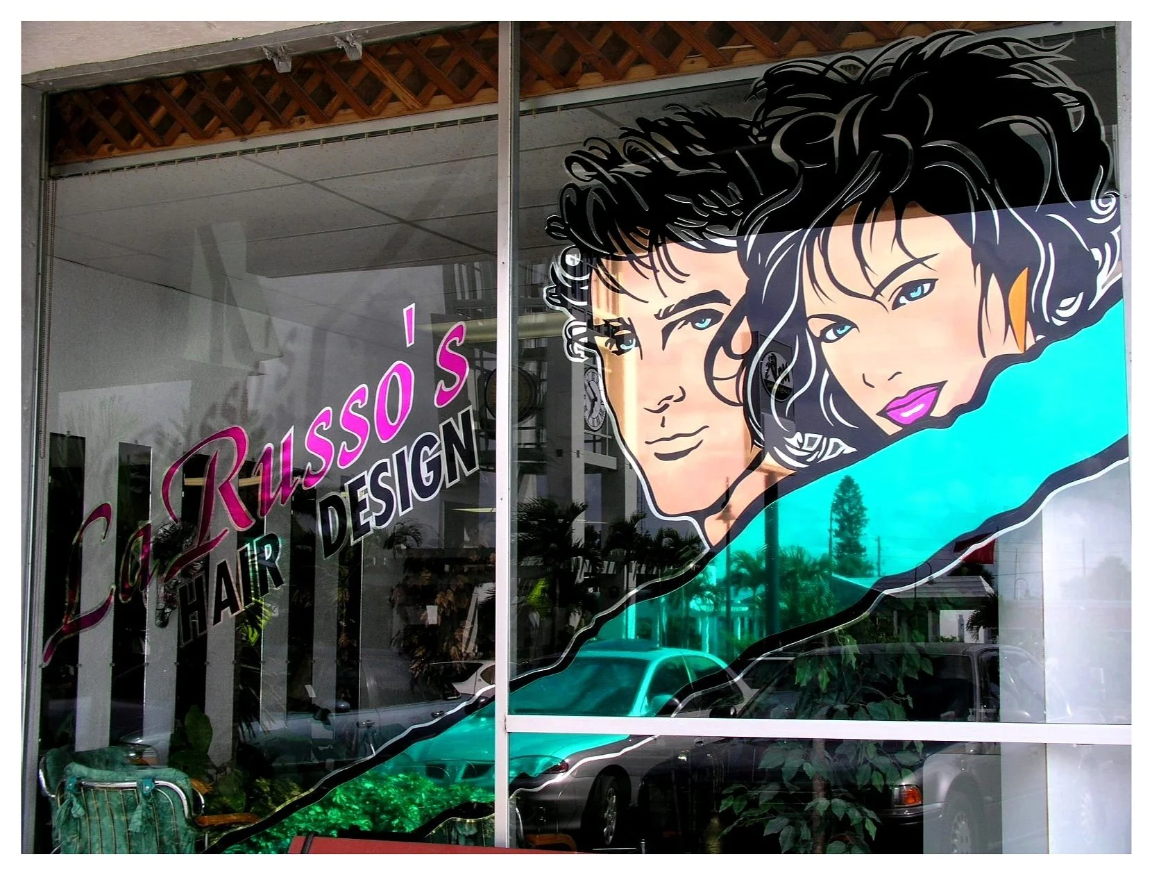 Shop window with "La Russo's Hair Design" name and illustration of a man and woman with stylish haircuts. colored window film