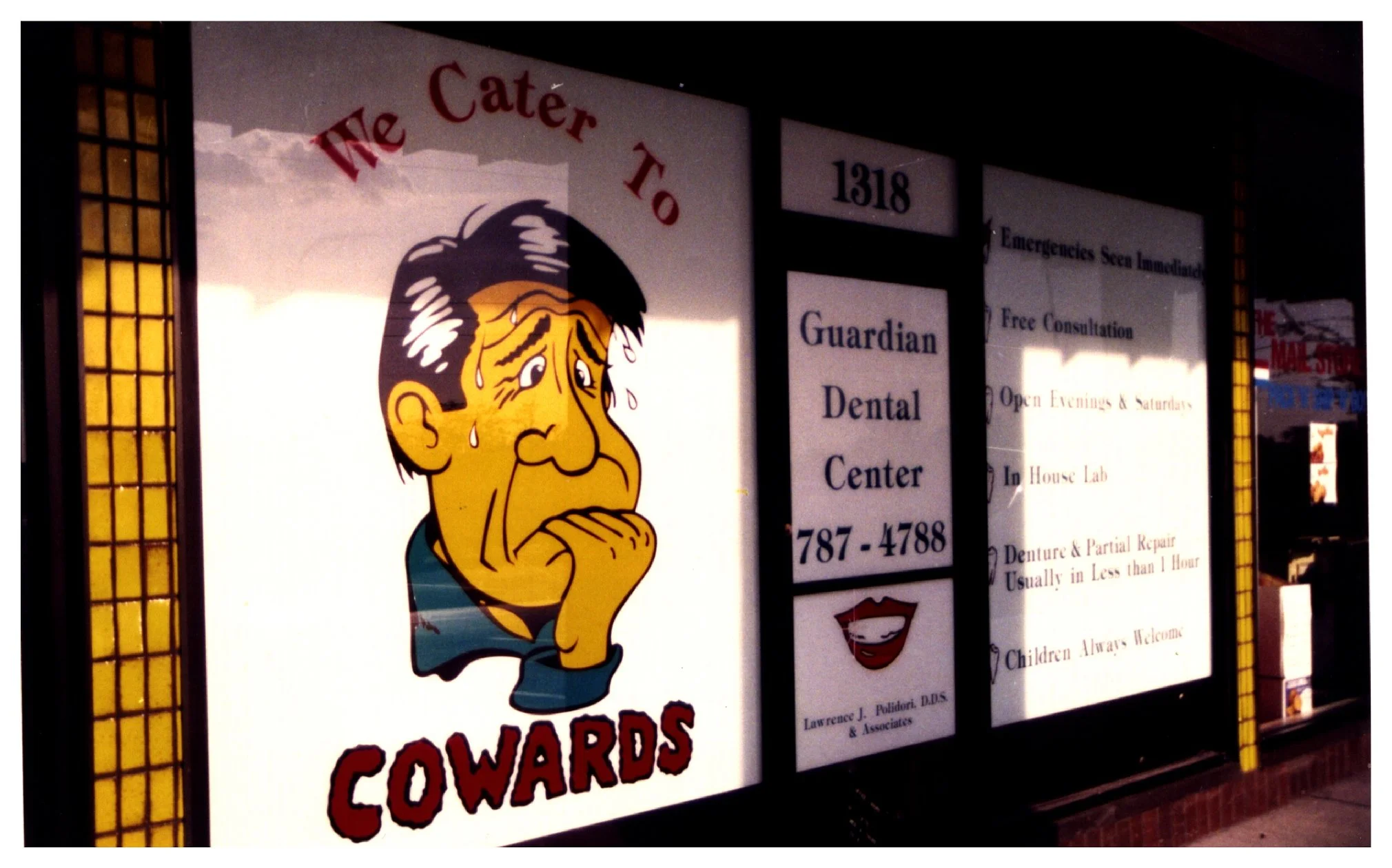 Window of Guardian Dental Center with a cartoon face and text "We Cater To Cowards." colored window film
