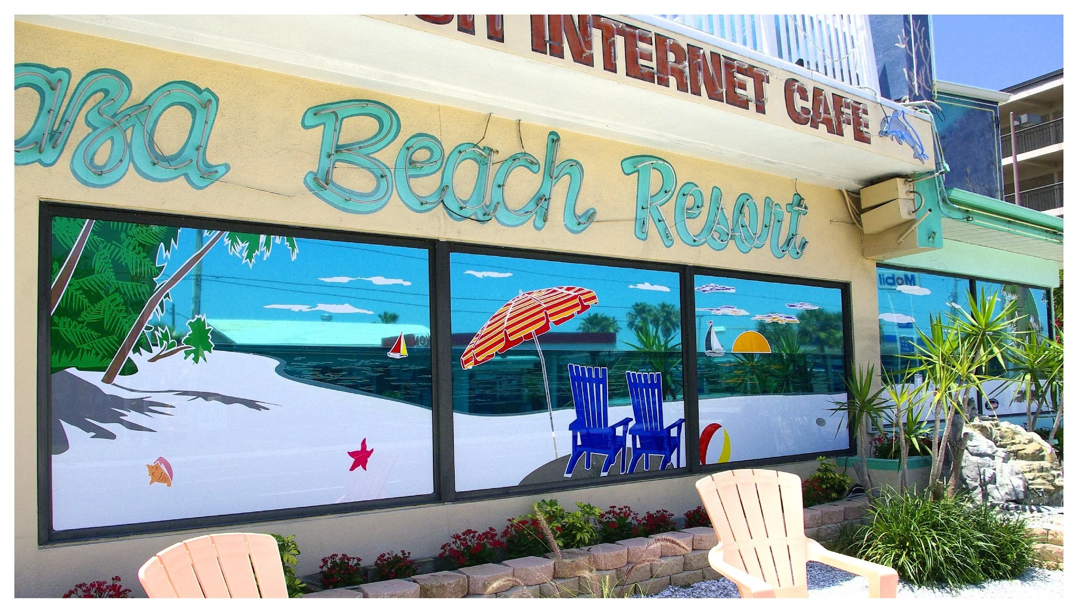 Beach resort exterior with colorful mural and signs in tropical themed decor. colored window film