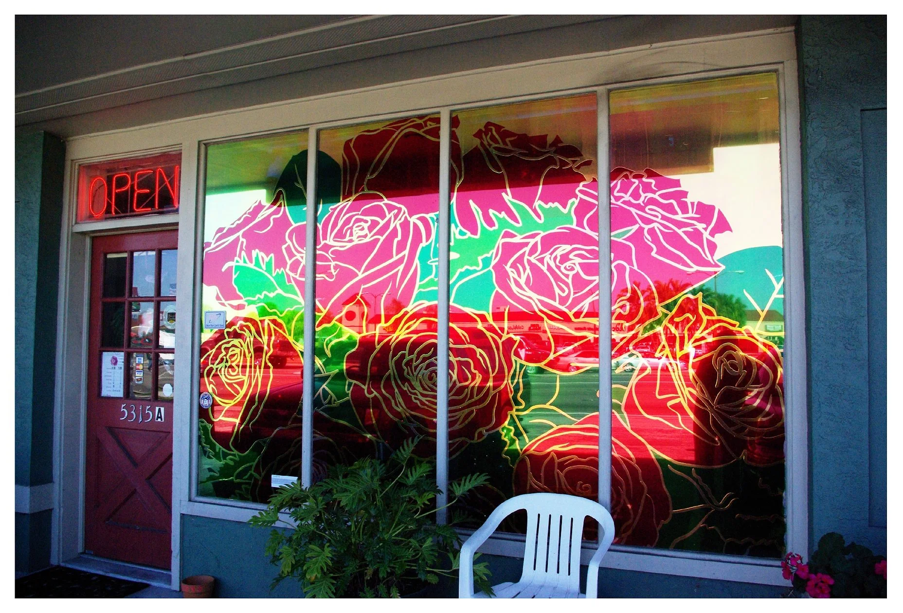 Storefront with vibrant rose-themed stained glass design colored window film