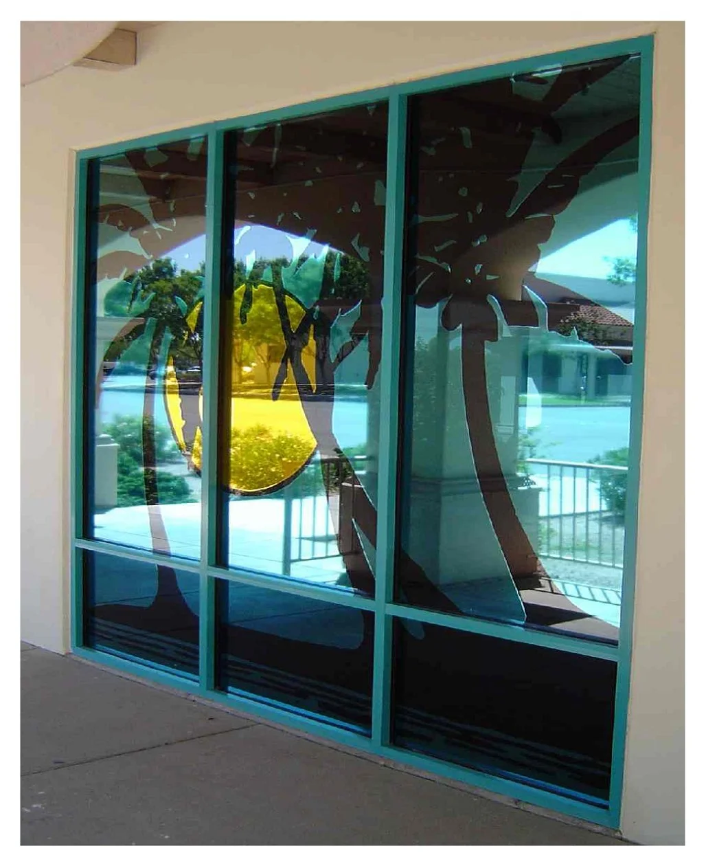 Glass storefront with palm tree and sun graphics colored window film