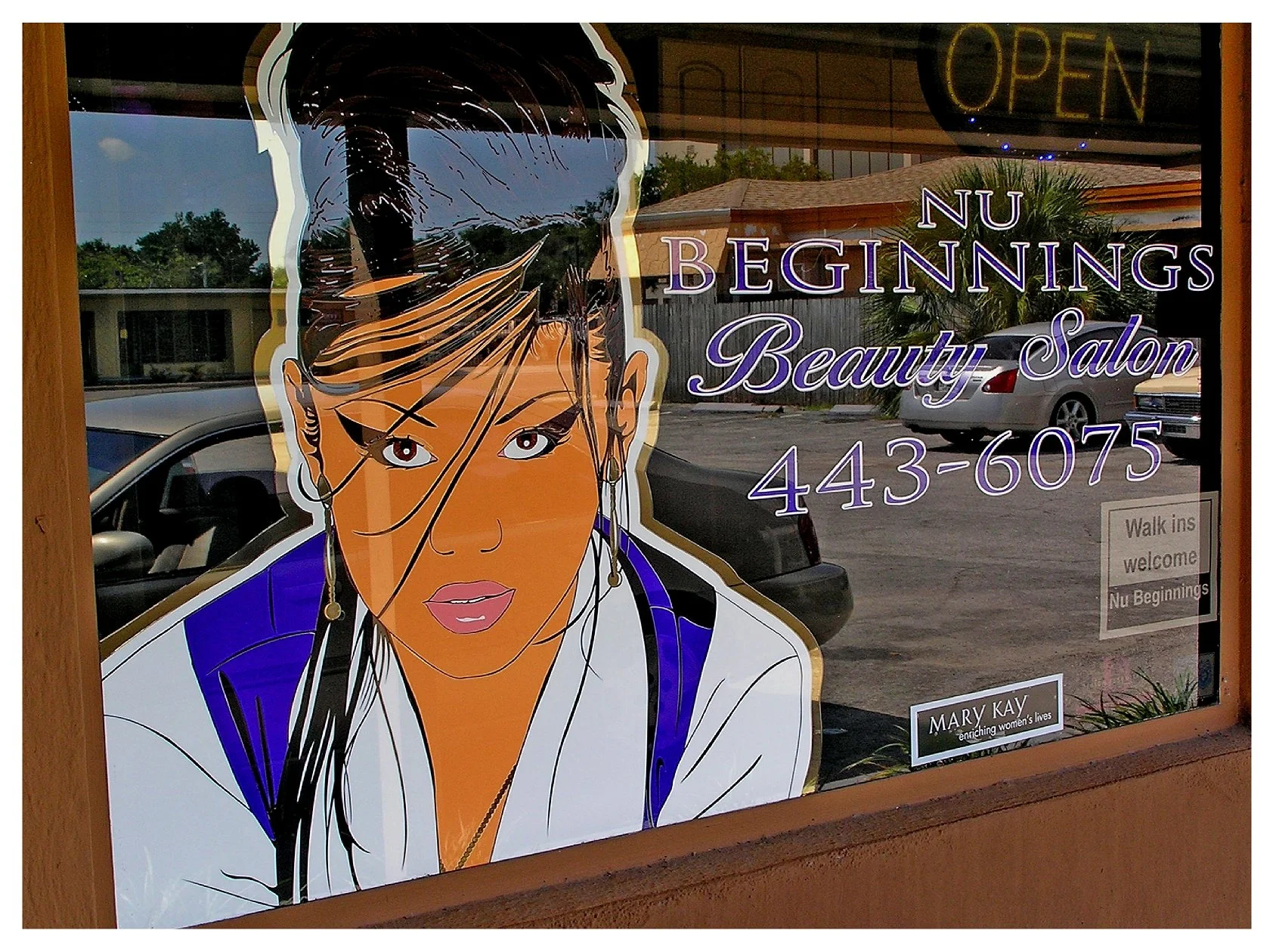 Nu Beginnings Beauty Salon window with illustrated woman, salon name, and contact number. colored window film