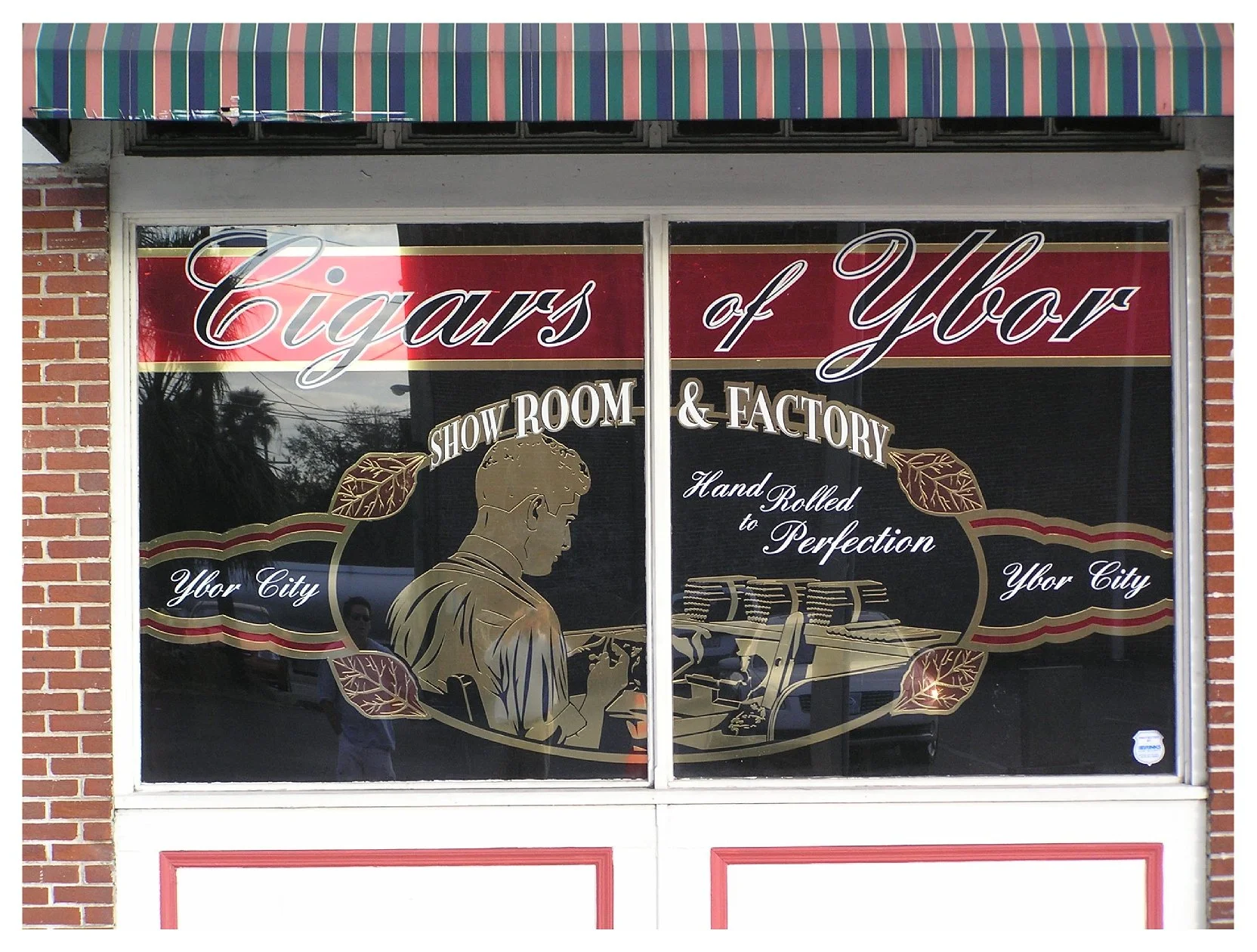 Shop window with "Cigars of Ybor" logo, showroom and factory advertisement, hand rolled cigars artwork, Ybor City theme colored window film