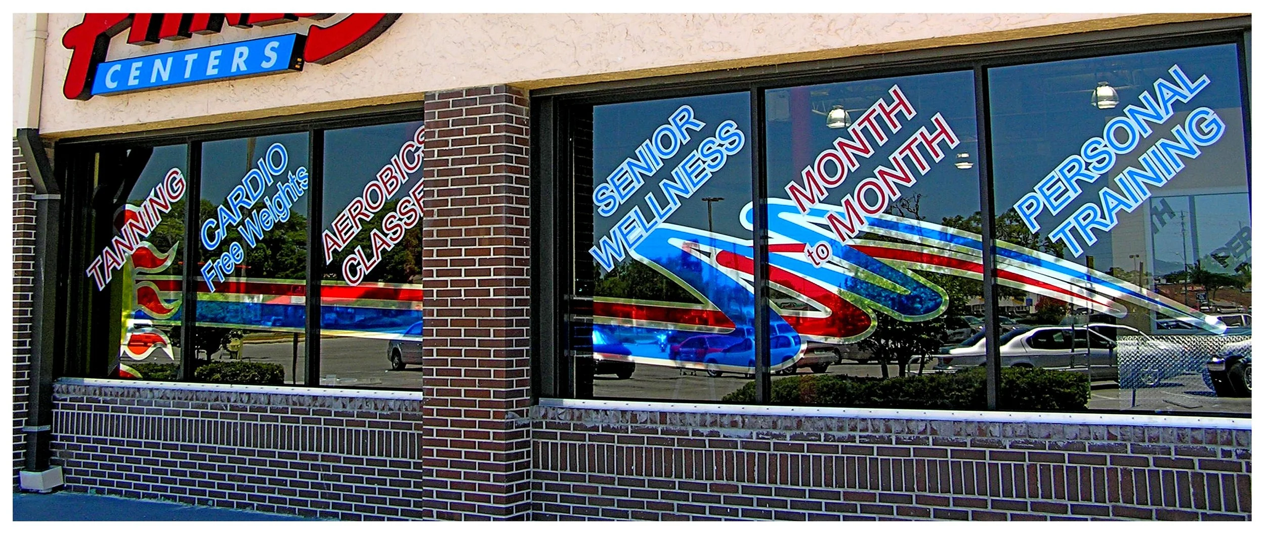 Gym storefront with fitness services advertised on windows. colored window film