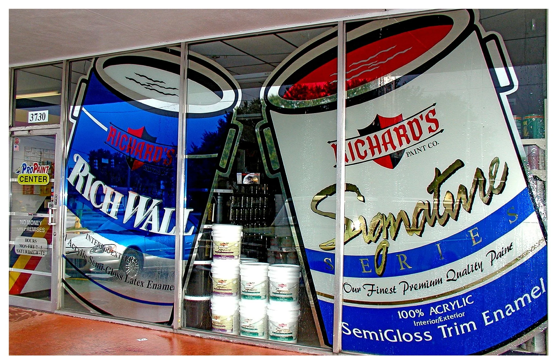 Storefront window advertisement for Richard's Paint featuring large paint cans graphics with "Rich Wall" and "Signature Series" text, promoting premium quality acrylic enamel. colored window film