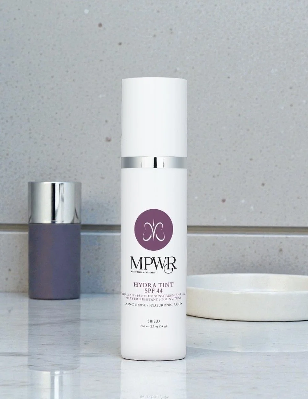 White bottle of MPWR Hydra Tint SPF 44 broad spectrum sunscreen with zinc oxide and hyaluronic acid, 2.1 oz/59g.