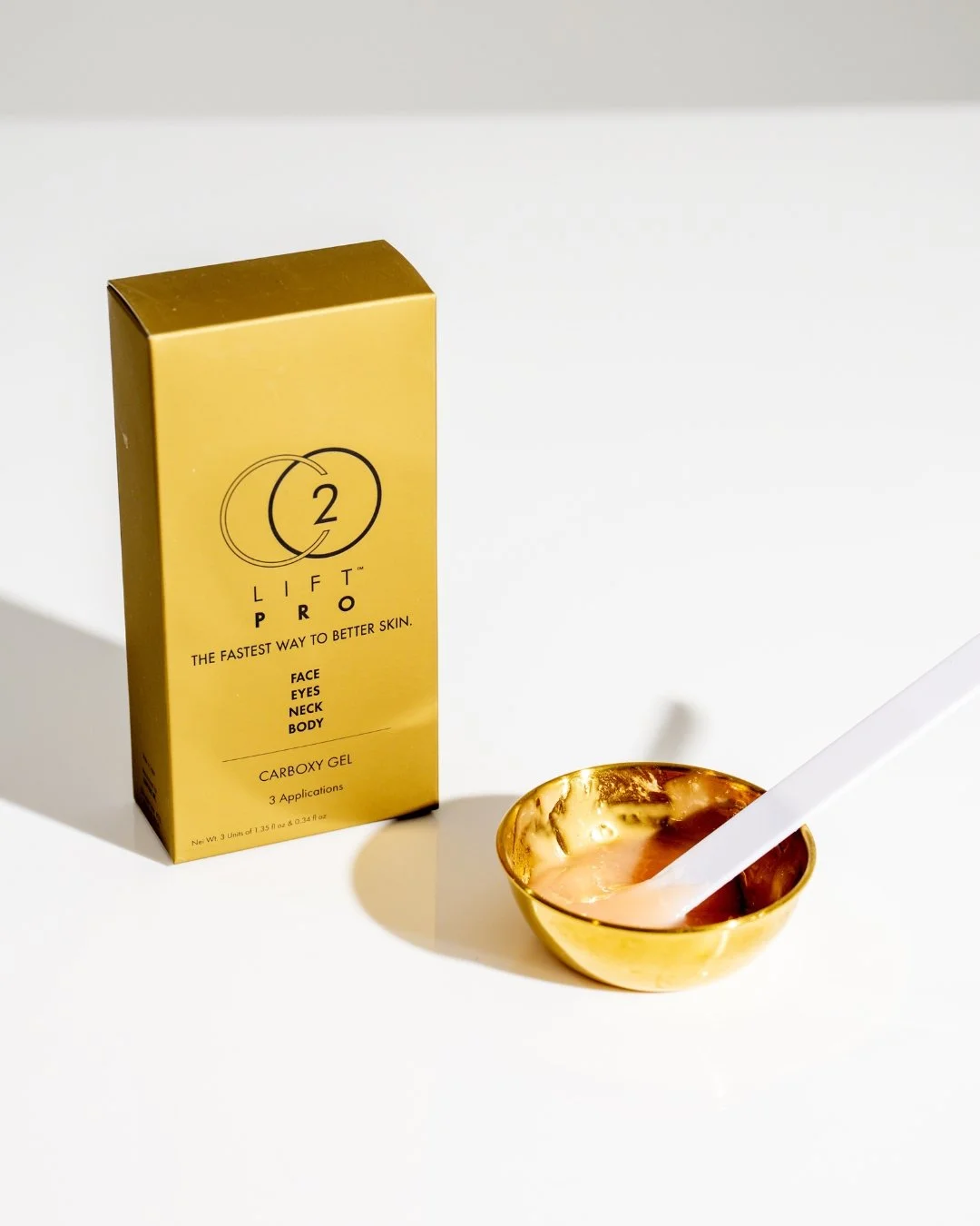 Patient applying CO2Lift Pro carboxytherapy gel in a gold cup.