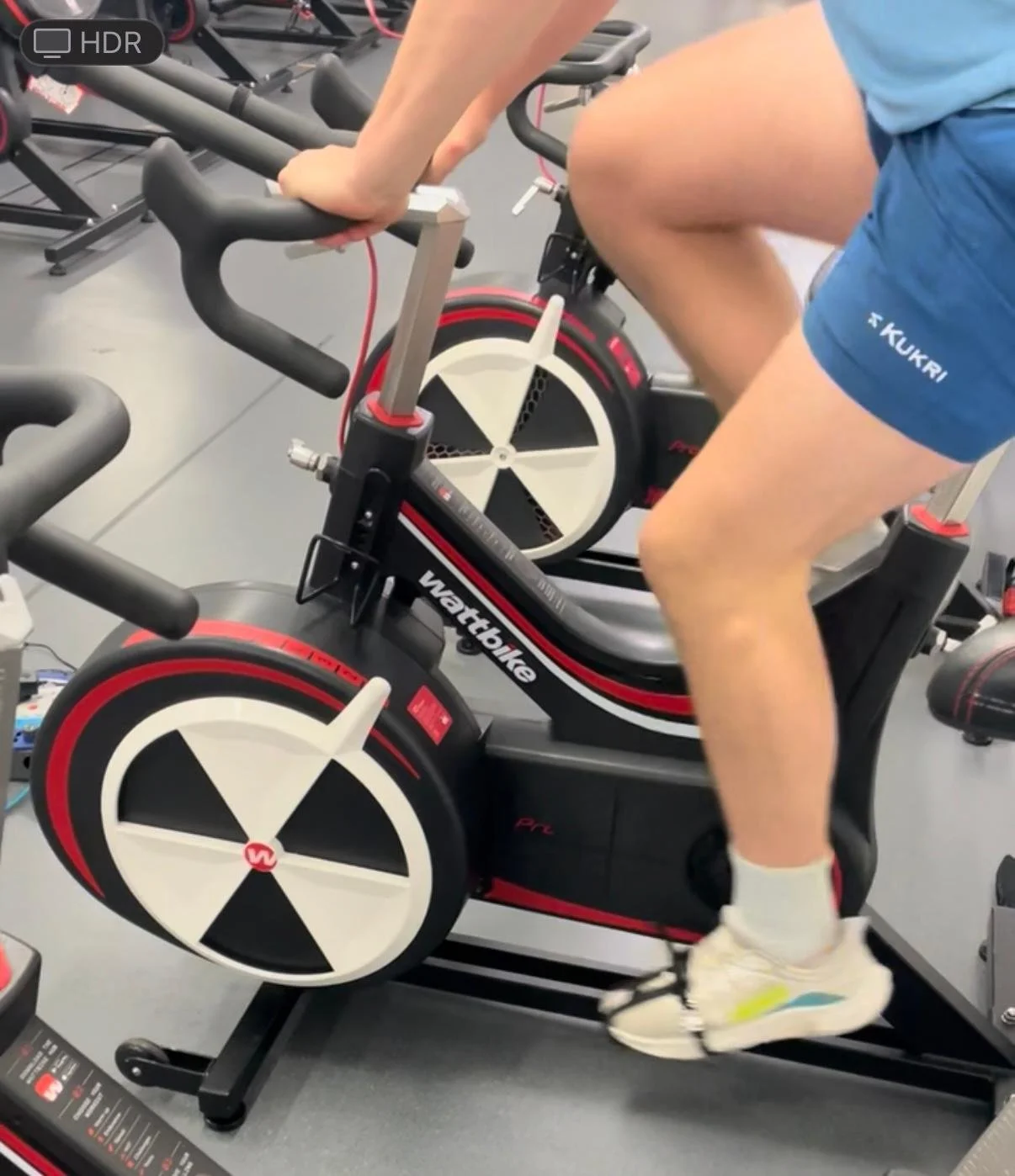 Person riding a stationary exercise bike in a gym.