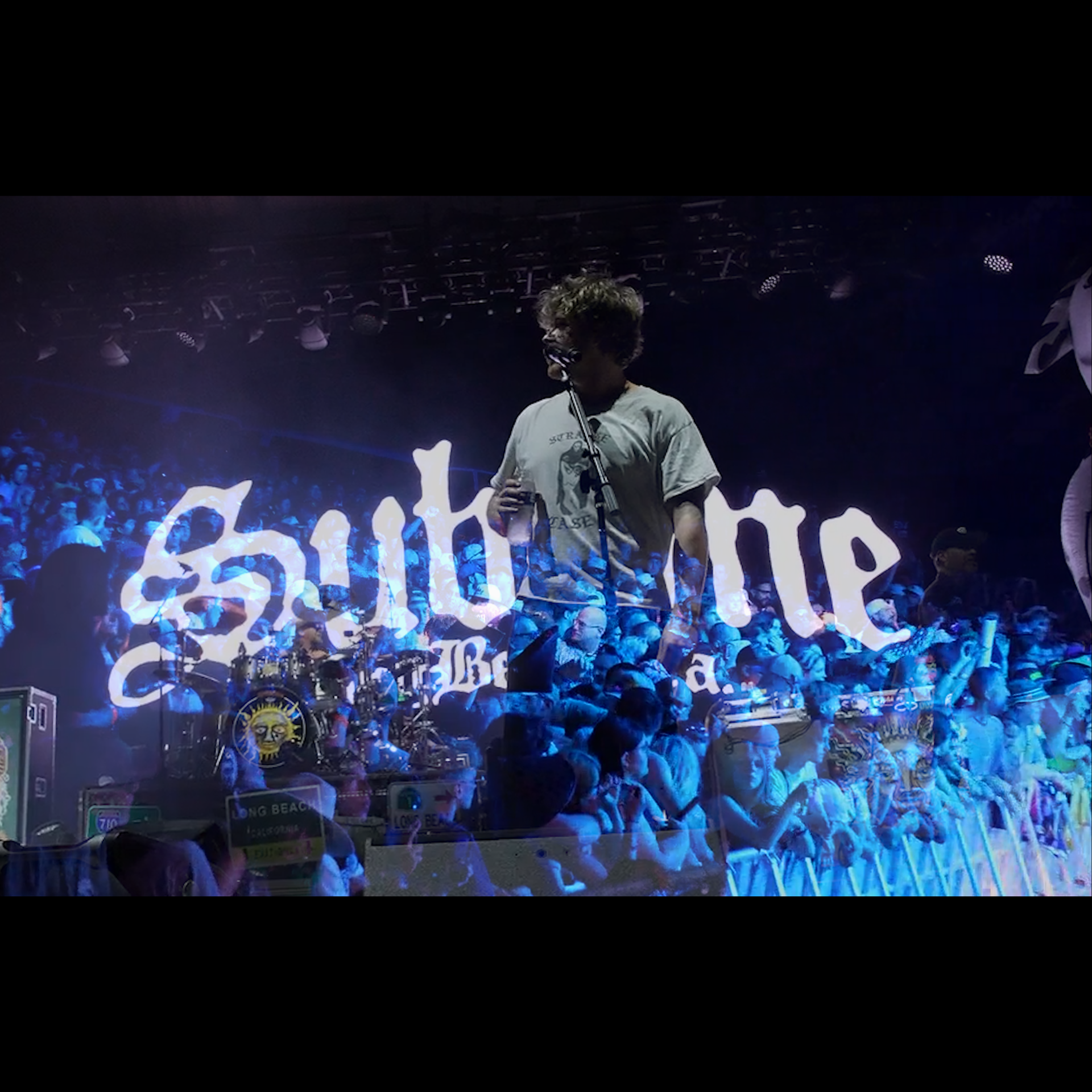 Cinematic wide shot of videographer filming band on stage at music festival with dramatic lighting