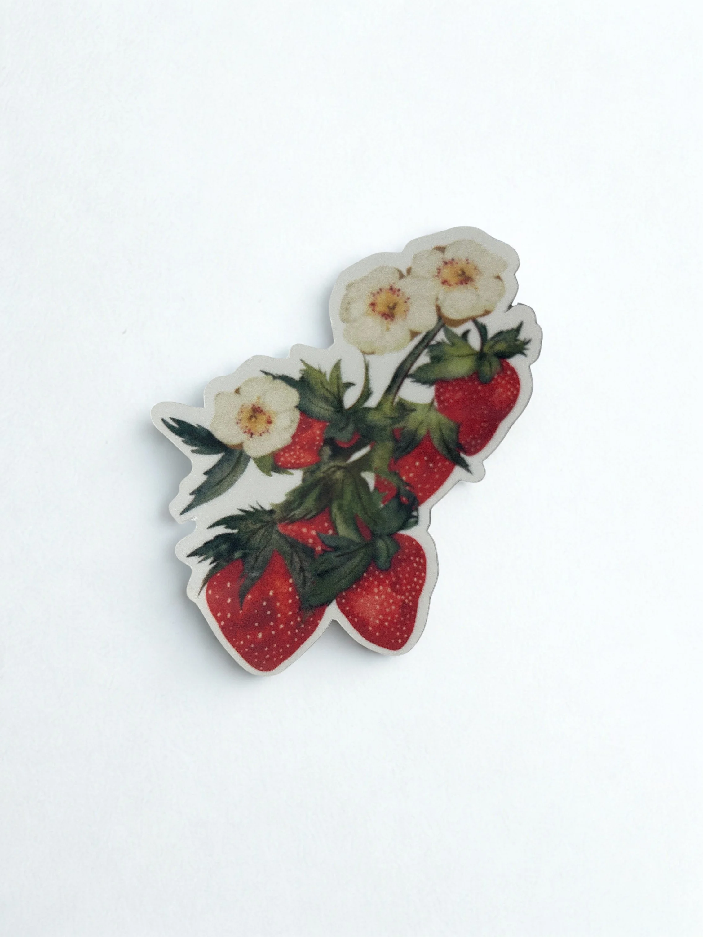 Hand-illustrated strawberry bunch die-cut sticker featuring ripe red strawberries, cream blossoms and leafy green stems.
