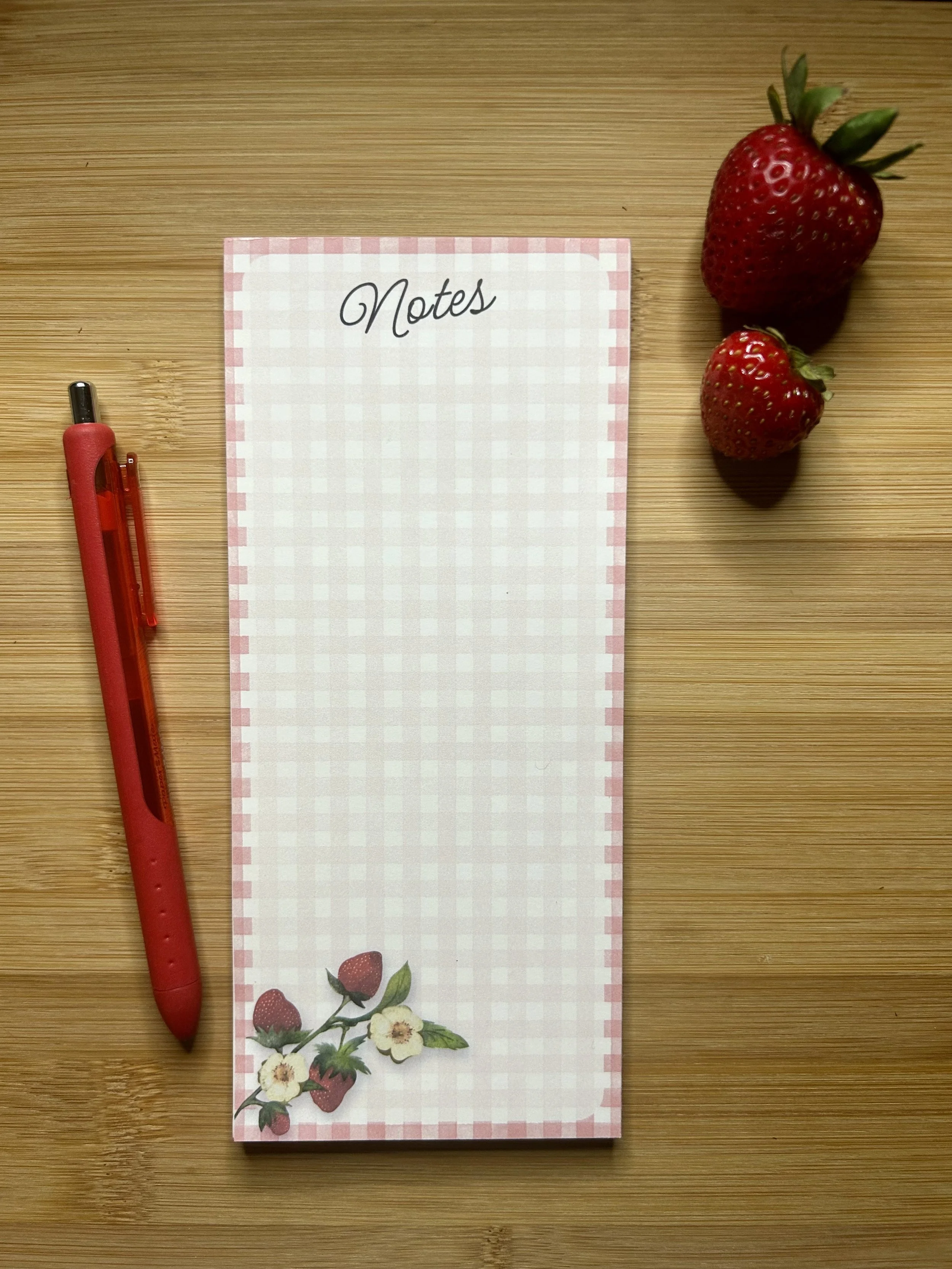 Handmade strawberry note pad with pink gingham border and two hand-illustrated red strawberries. Shown in 3.5 x 8 Note Pad