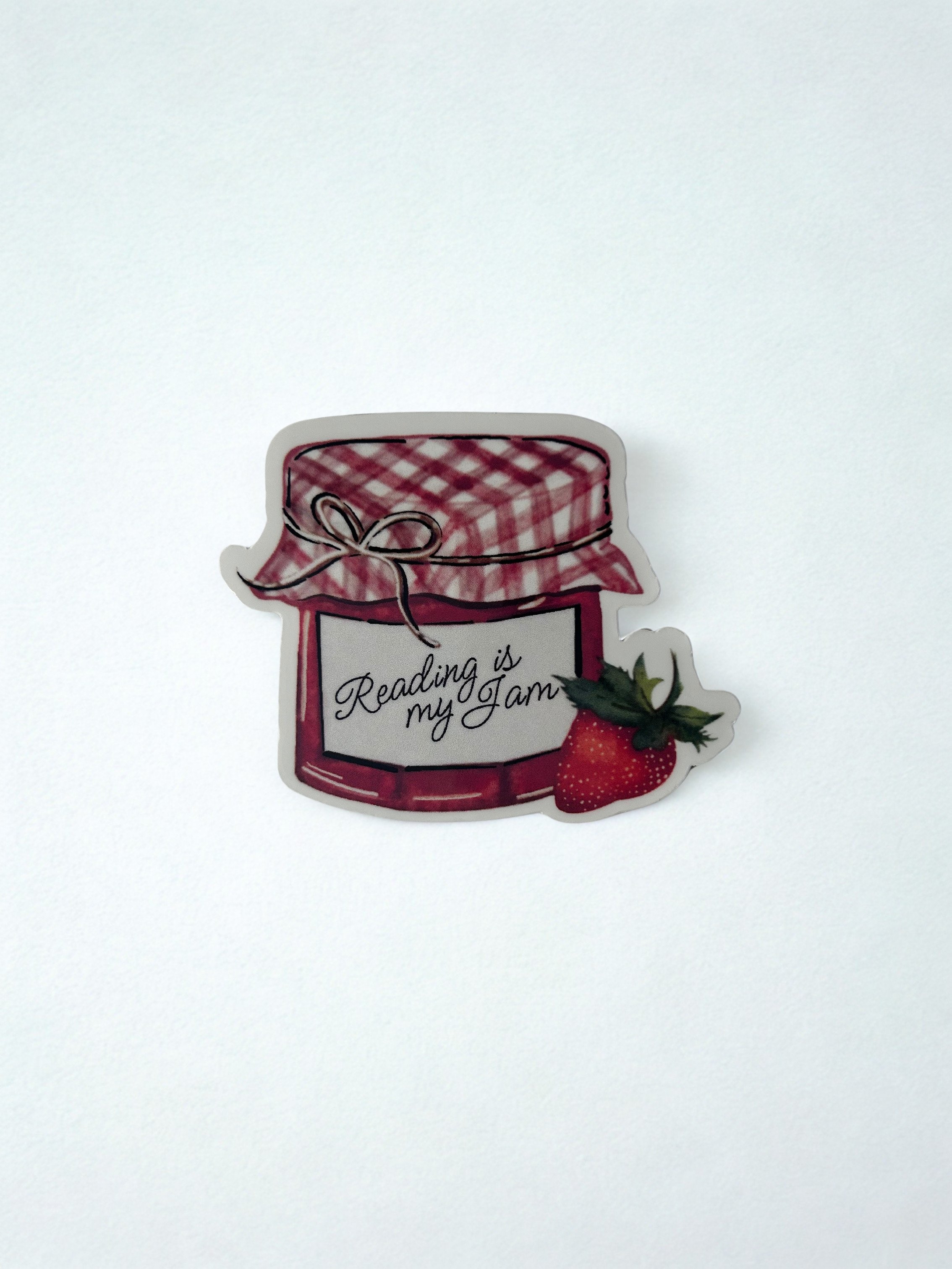 Hand-illustrated Reading Is My Jam strawberry preserves jar die-cut sticker with pink gingham lid and ripe strawberry.