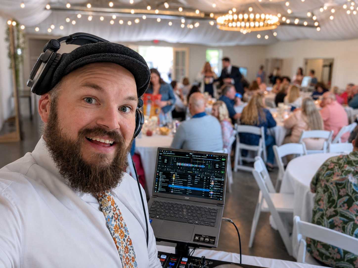 Wedding DJ selfie during a reception with guests dining in the background and professional DJ equipment setup by Jazzy Josh DJ & Events.