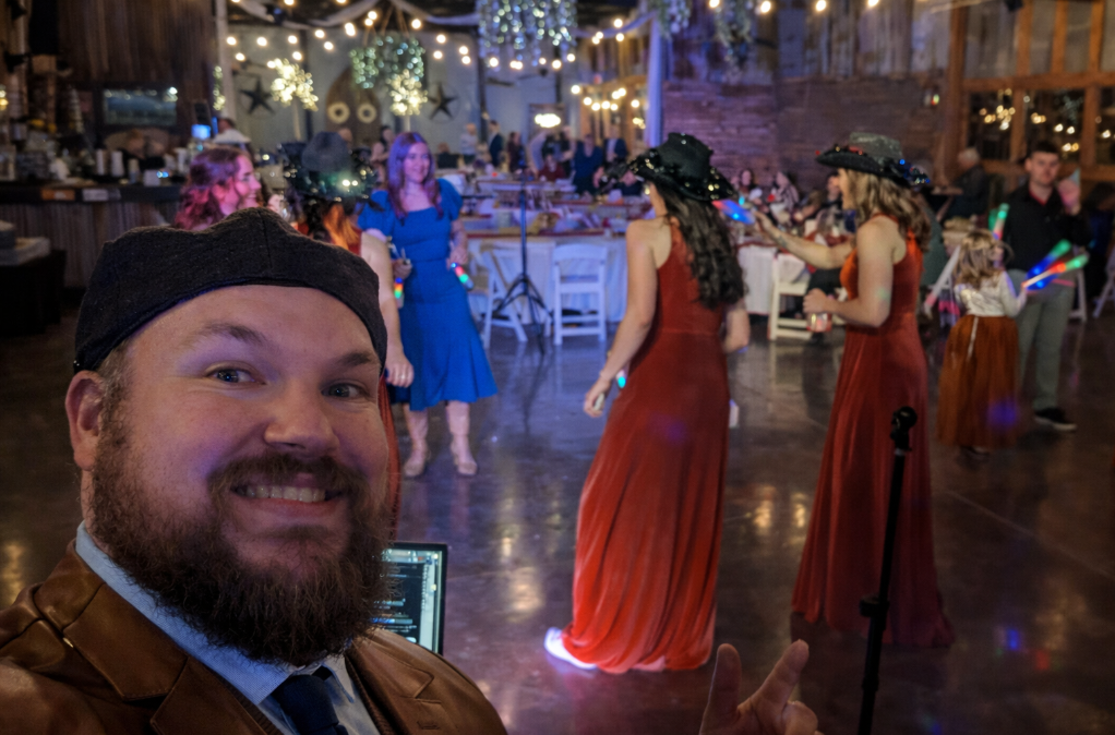 Wedding reception with bridesmaids dancing on the floor, elegant string lighting, and DJ Jazzy Josh providing entertainment and MC services