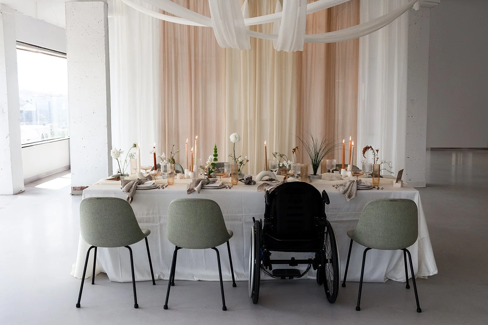 A table decorated and set for a party with three chairs and a wheelchair .