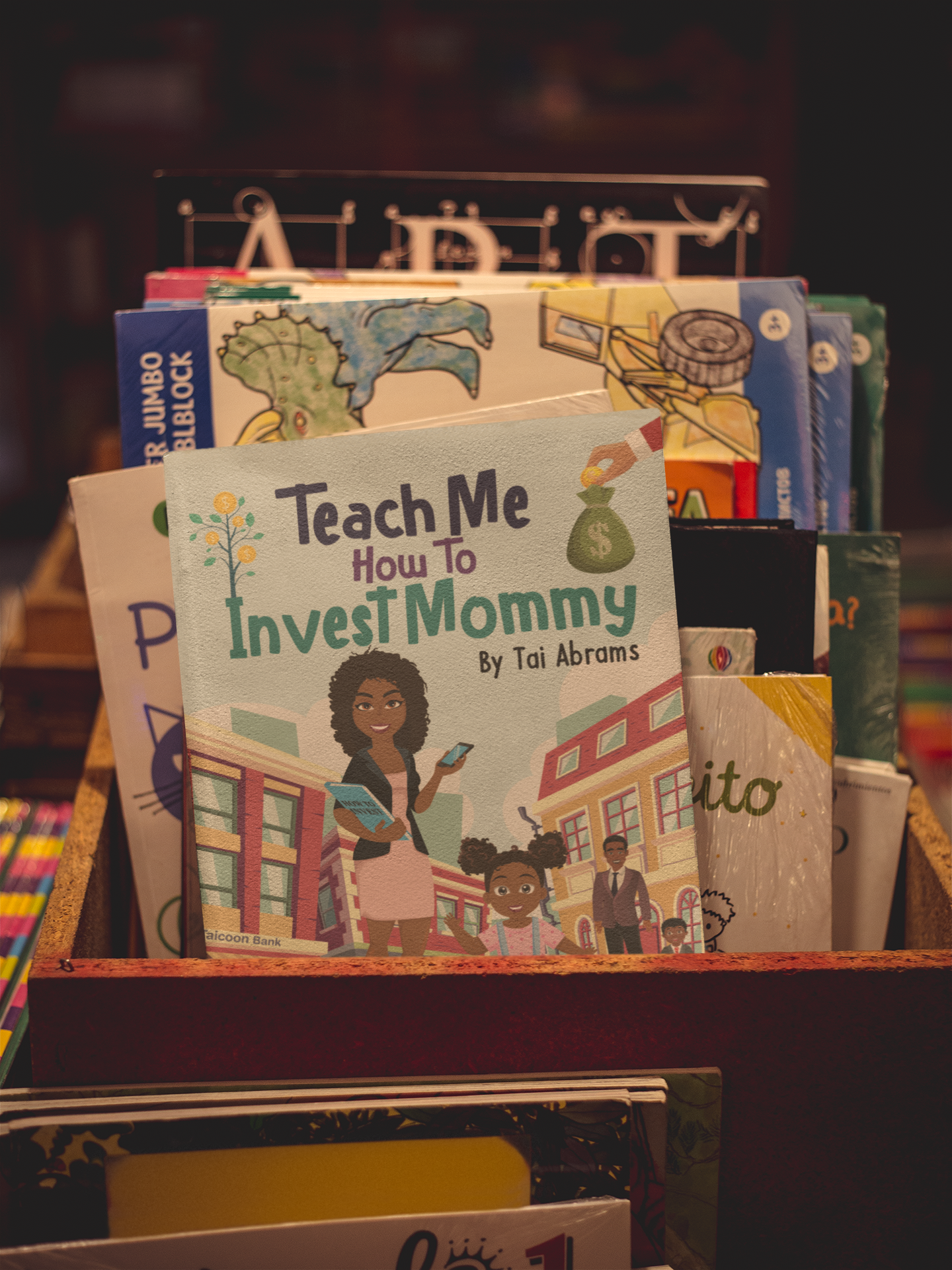 Teach Me How to Invest Mommy book-mockup-standing-against-other-books-on-a-shelf-a19284.png