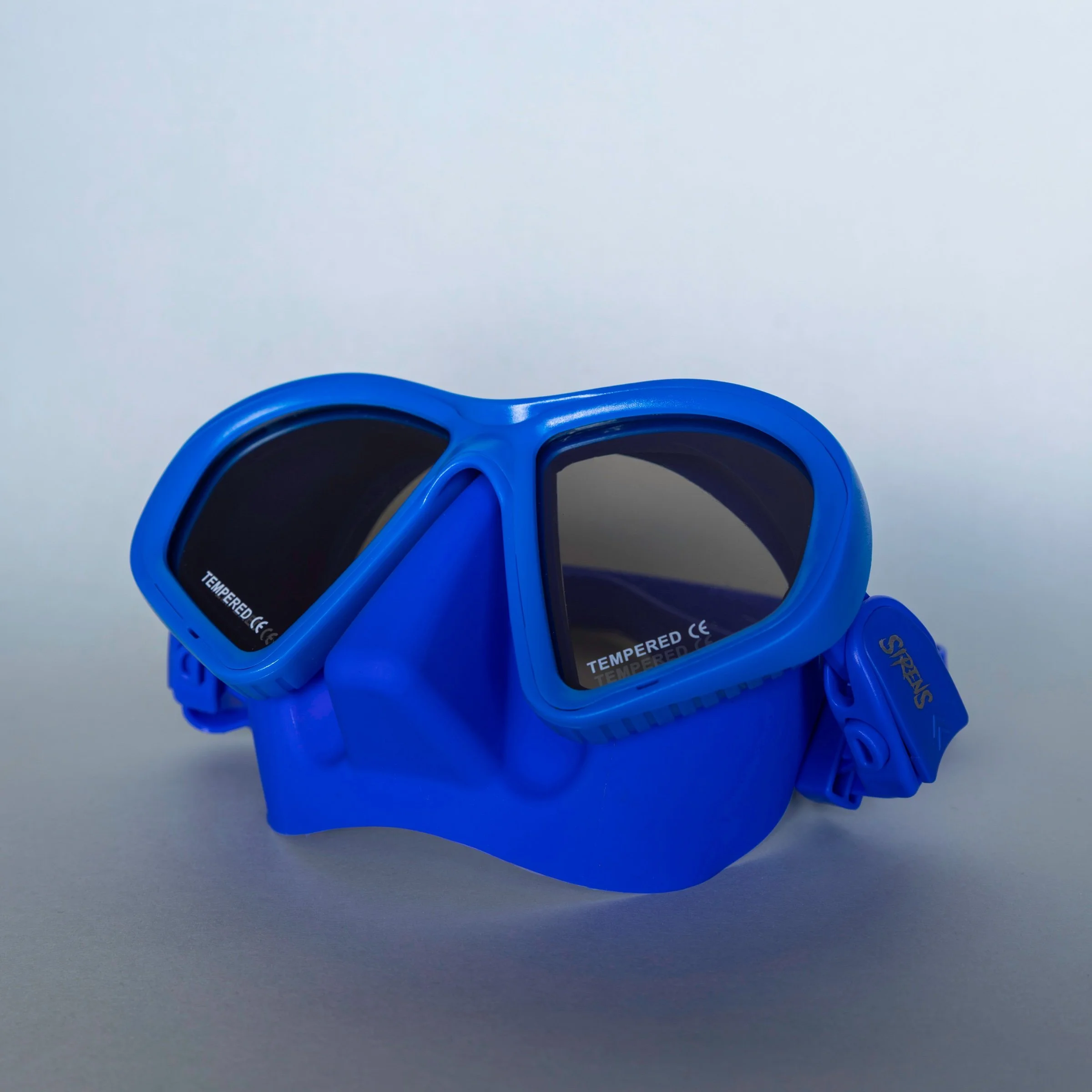 Blue Steel blue Sirens dive mask with dark reflective lenses on a neutral background
