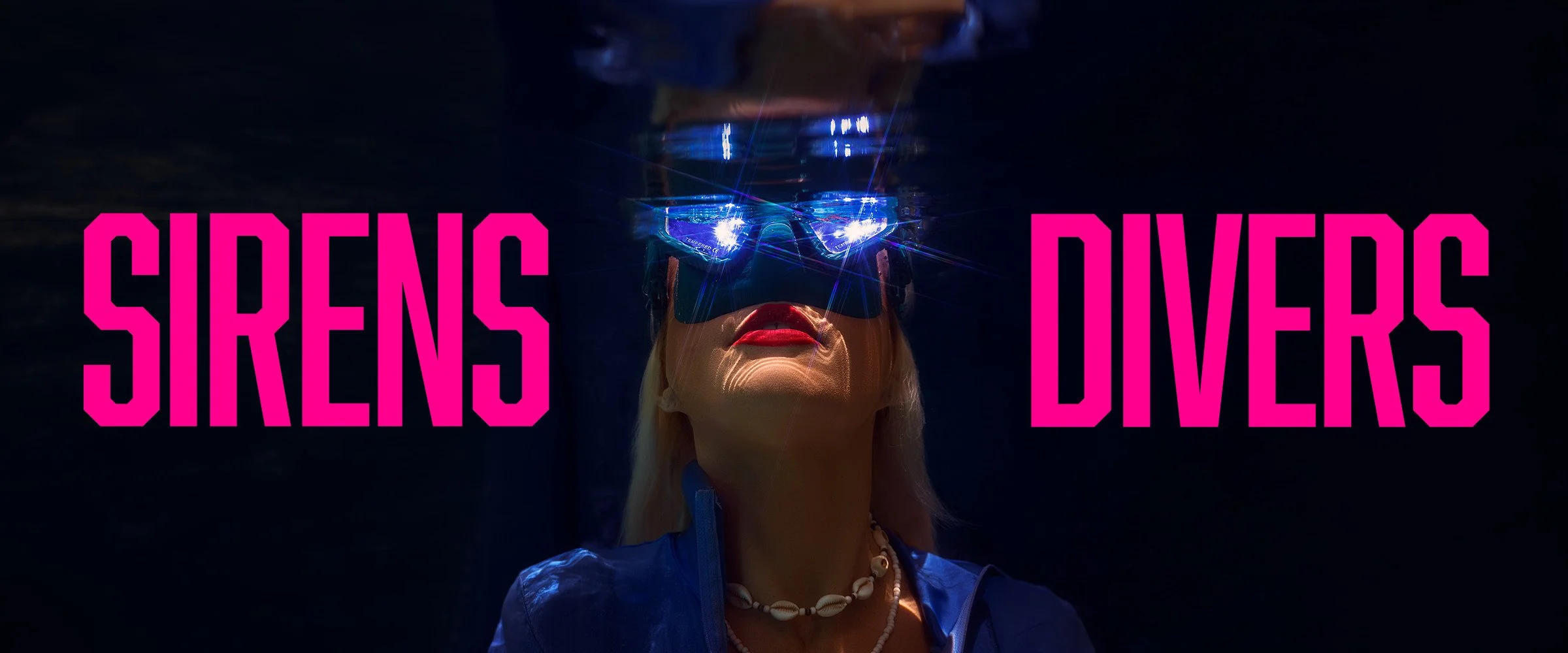Sirens diver wearing a reflective mask underwater, framed by bright pink SIRENS DIVERS lettering.