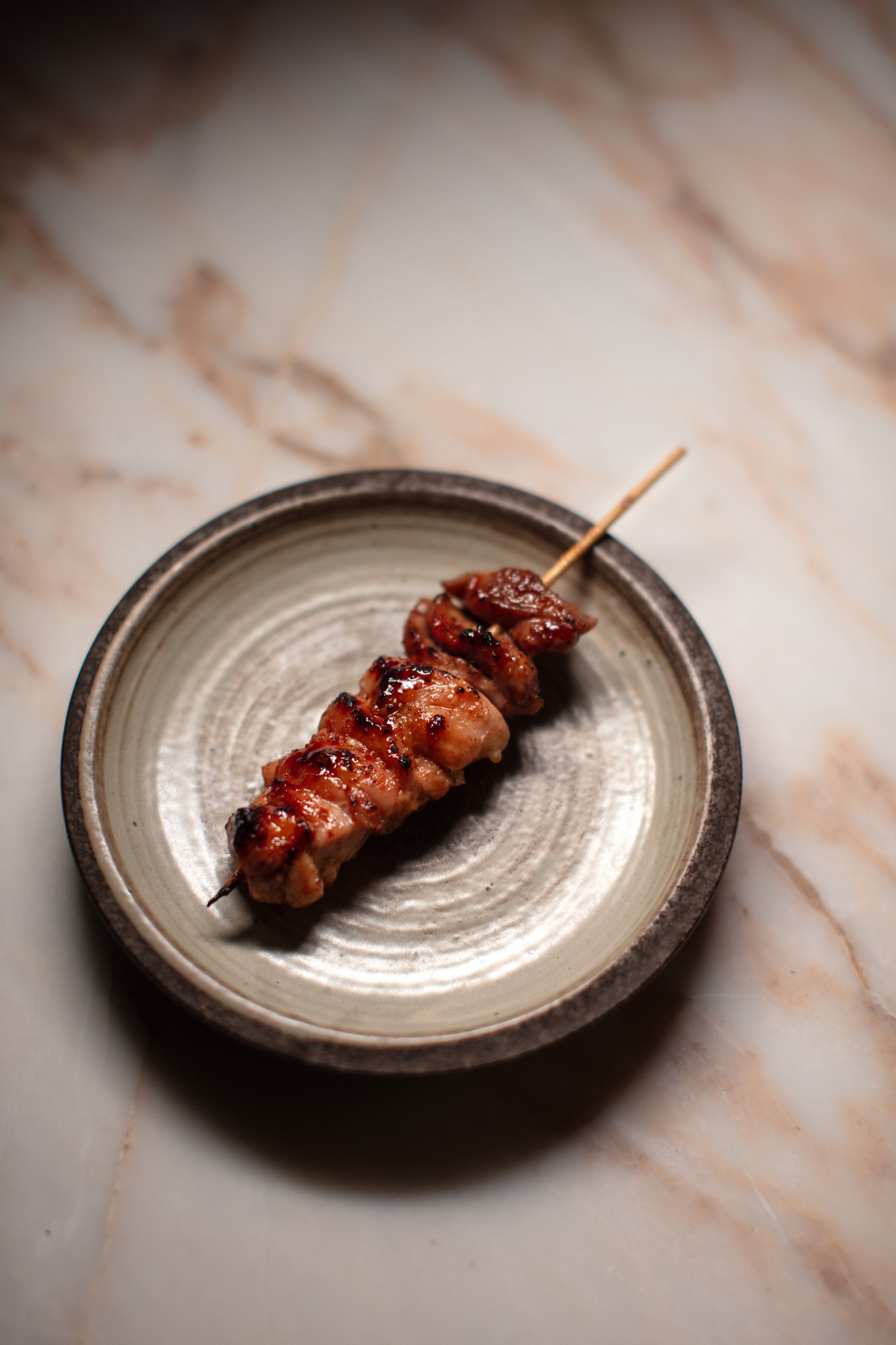 Grilled meat skewer on a plate.