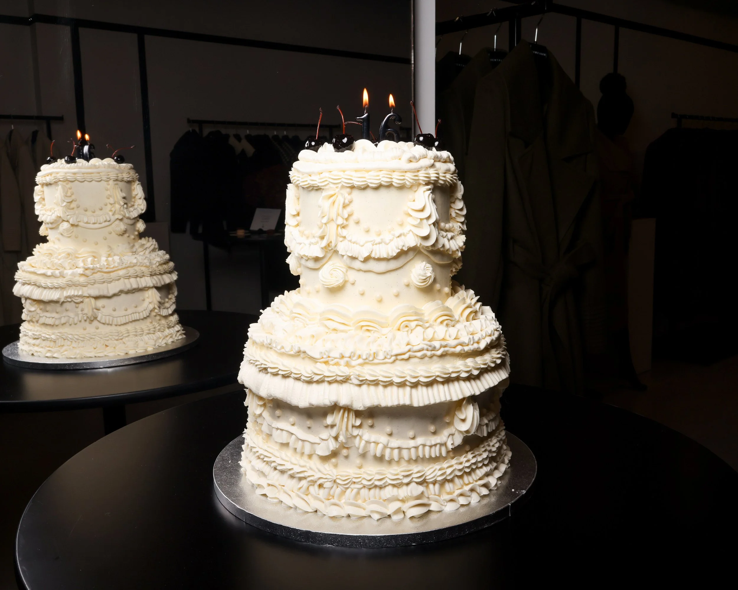 Two-tier Lambeth-style cake with vanilla frosting, layered vintage piping, 5 Luxardo cherries on top, and a "16" candle