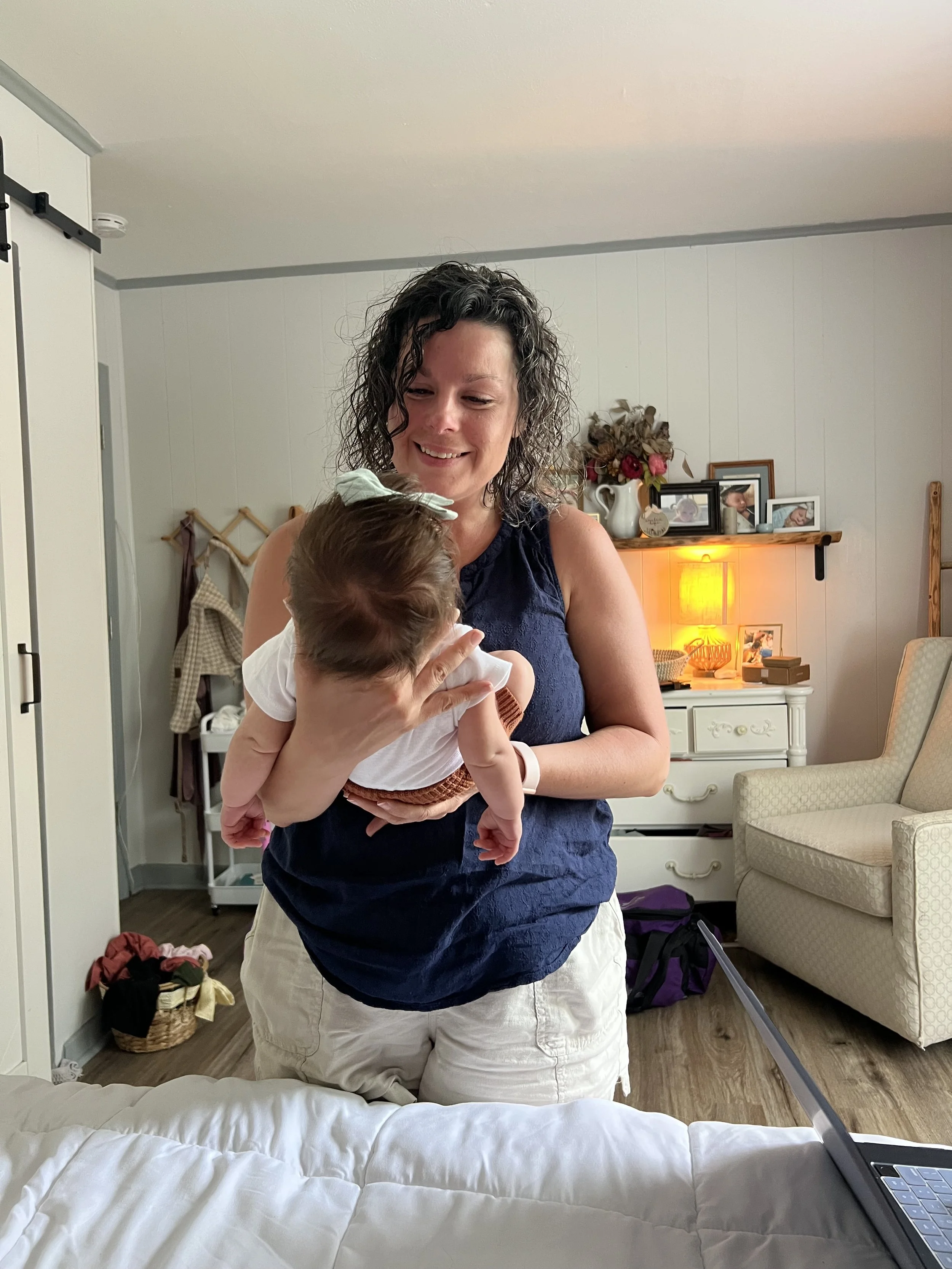 Certified Professional Midwife holding a newborn during a postpartum visit in Knoxville, TN