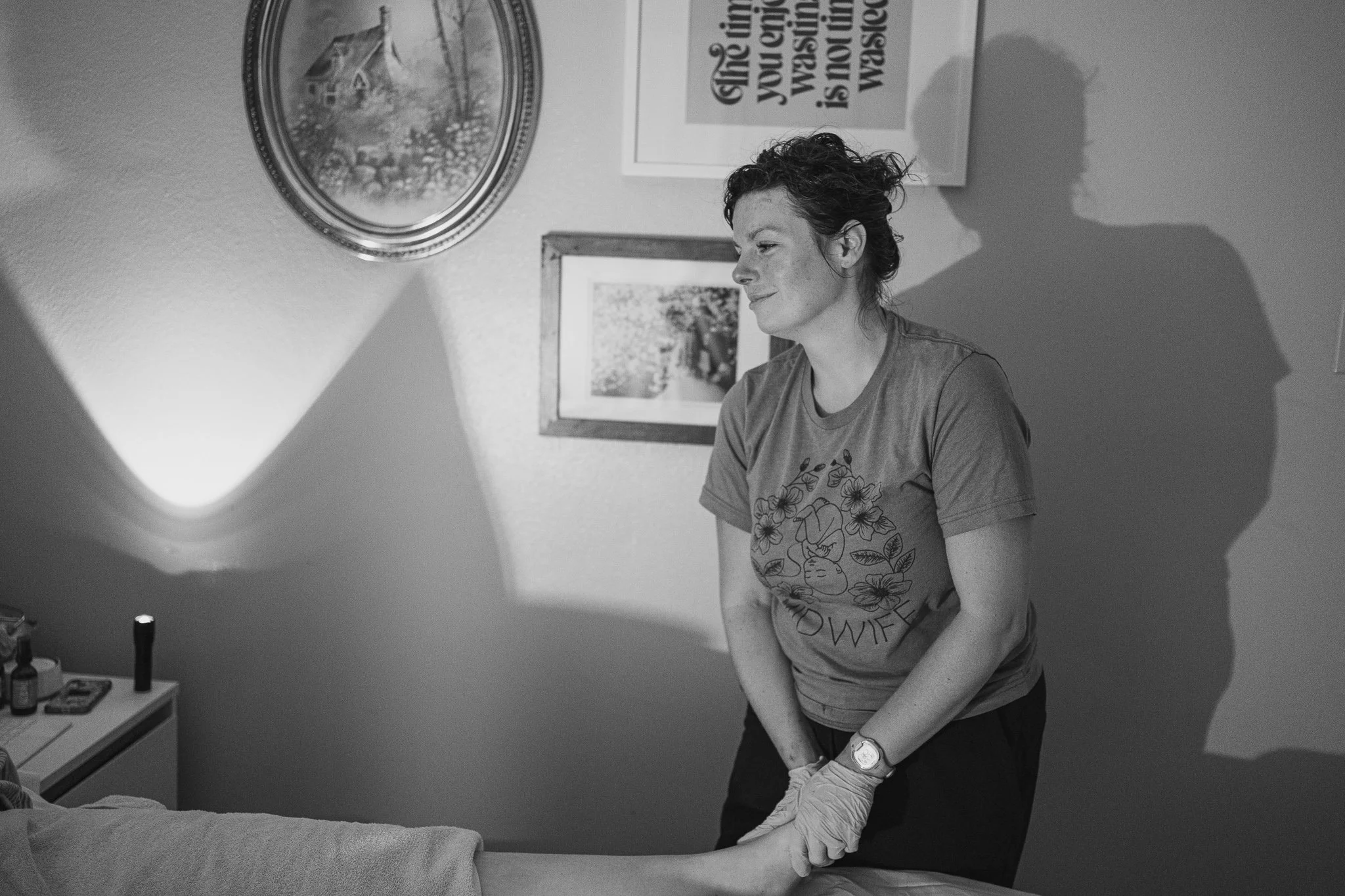 Certified Professional Midwife providing postpartum care and giving a foot massage to a mother after a home birth in Maryville, TN