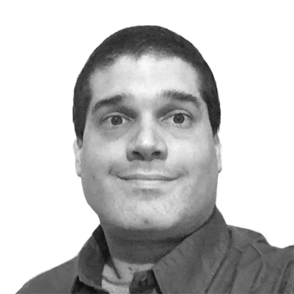 Black and white photo of a man with short dark hair, wearing a collared shirt, smiling slightly.