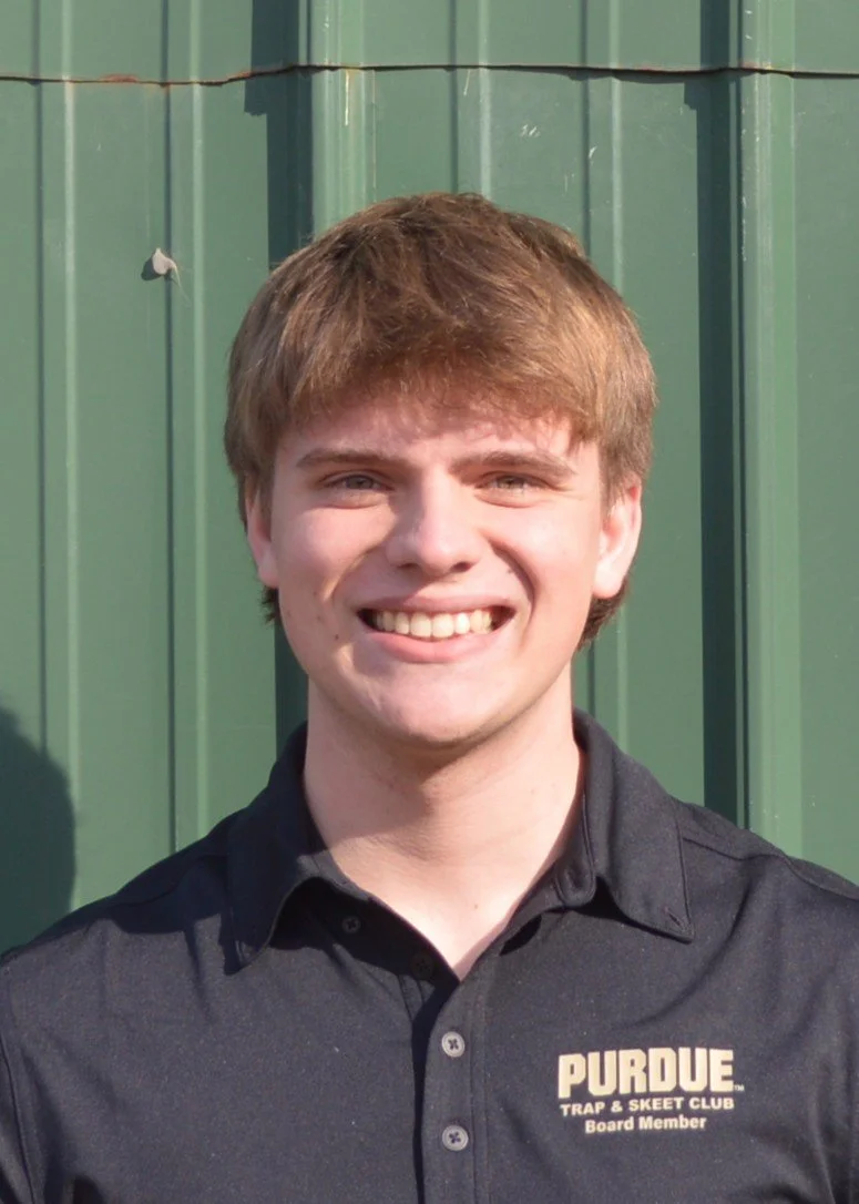 Person smiling in a dark green hoodie with a "P" logo and a Nike swoosh, standing against a light brick wall.