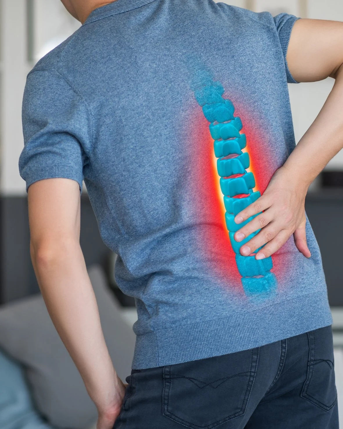 Person holding lower back with digital illustration of spine and highlighted pain area.