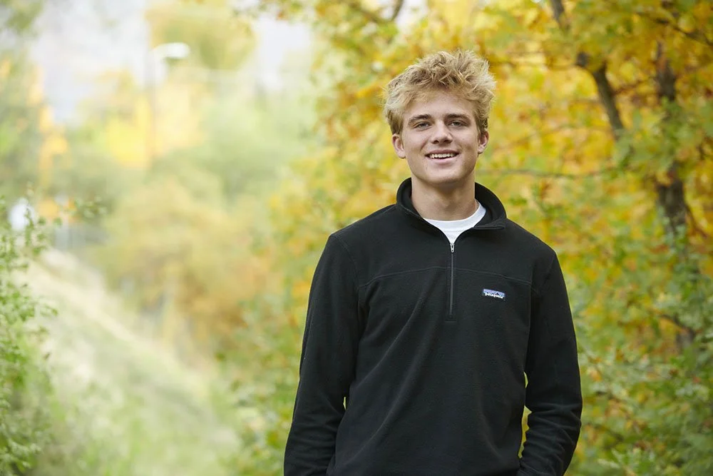 senior portrait of teen boy with tousled hair in fall scene