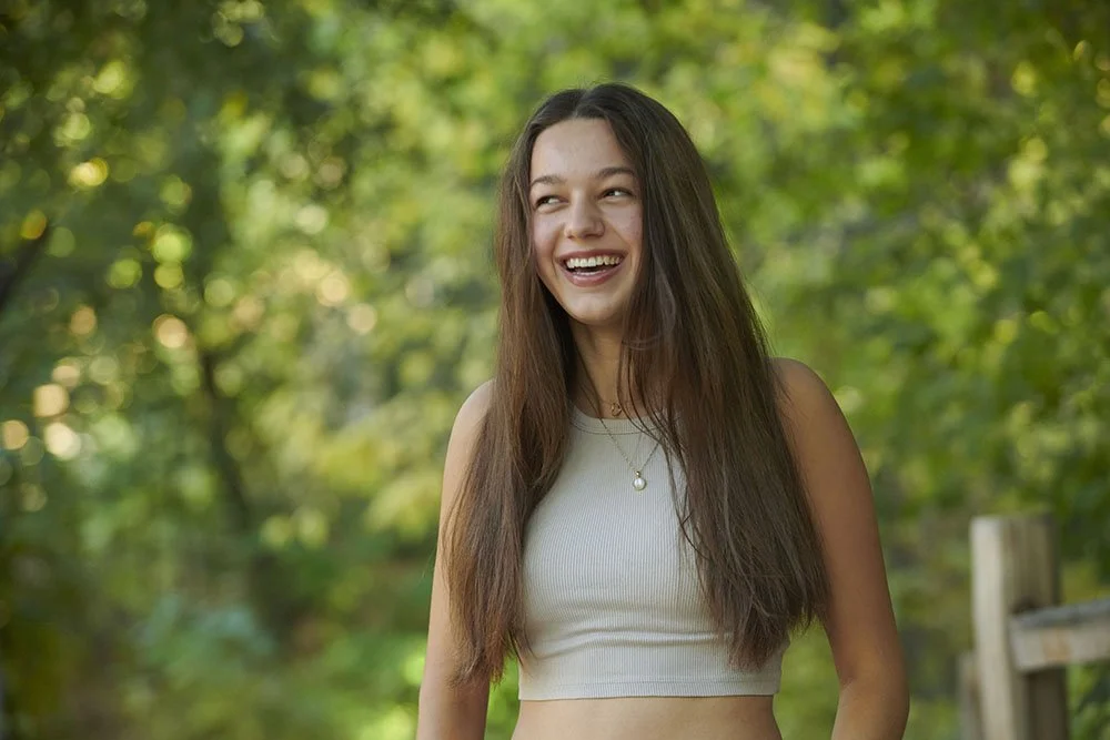 senior portrait of teen girl with long brown hair laughing