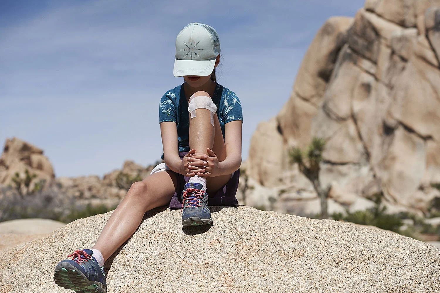 Kirsten Hepburn Photography portrait of a girl sitting on a boulder in Joshua Tree