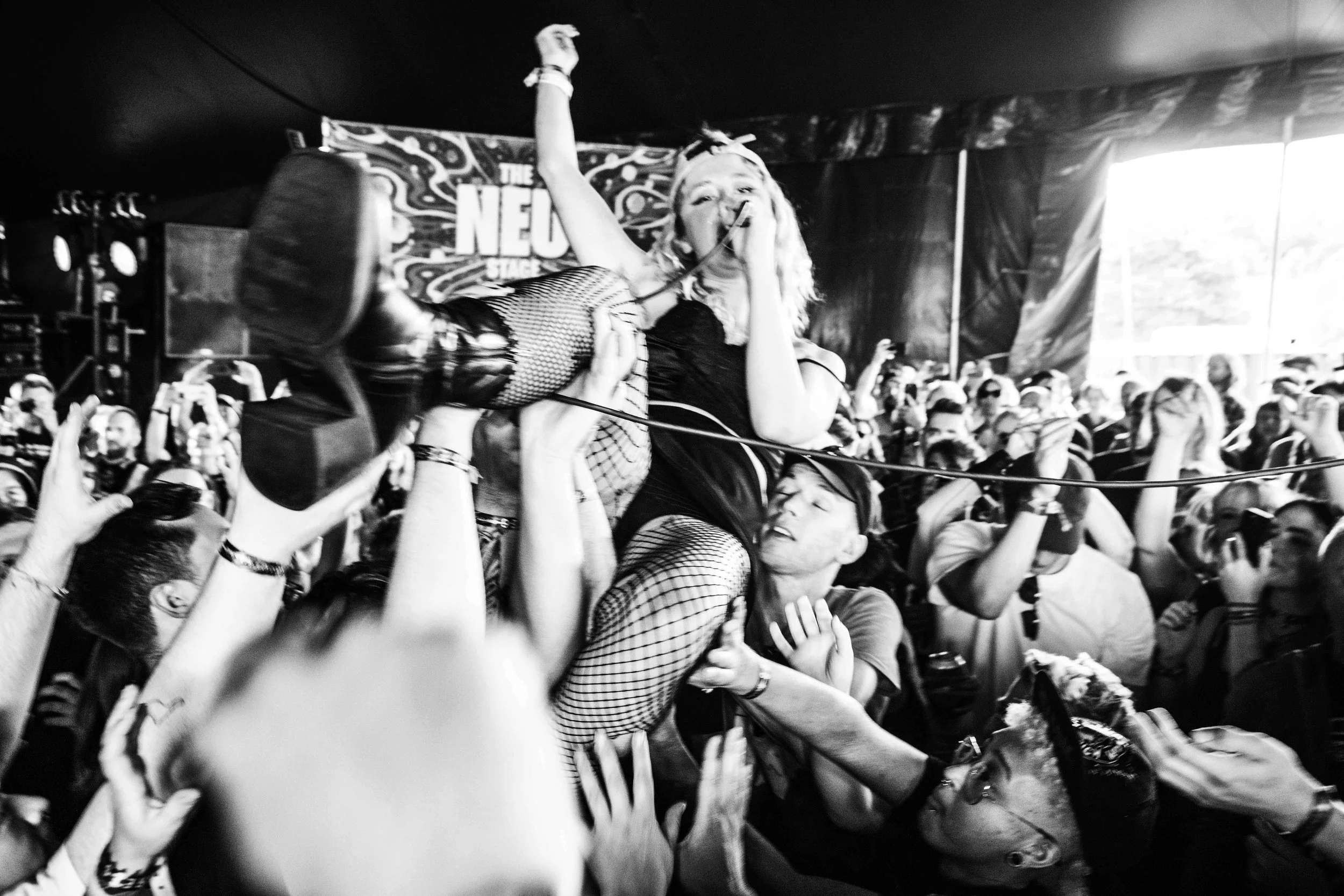 A woman being lifted by fans during a concert or music event.