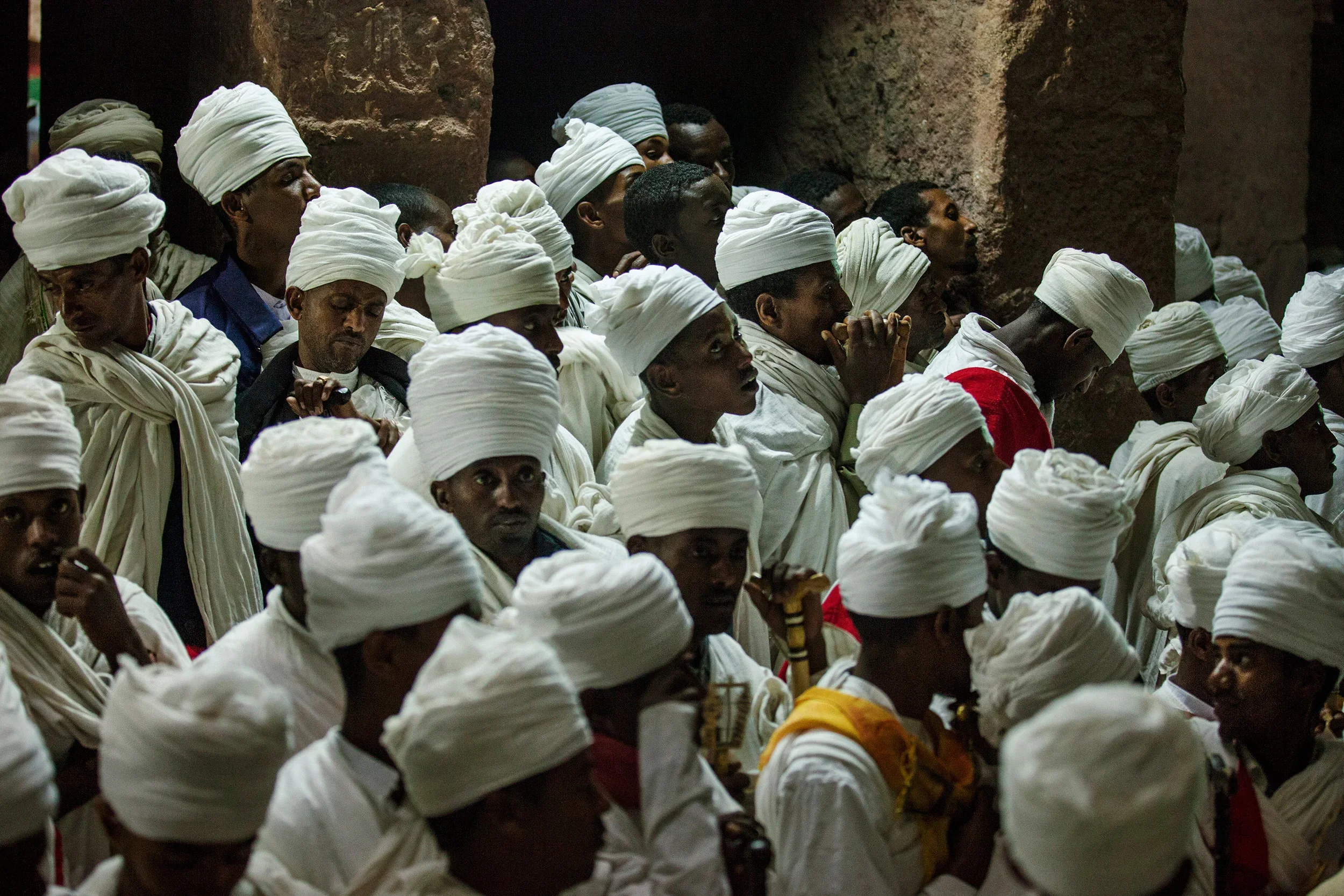 A-group-of-deacons-by-a-rock-church-during-the-final-celebrations-in-Lalibela,-Ethiopia.webp