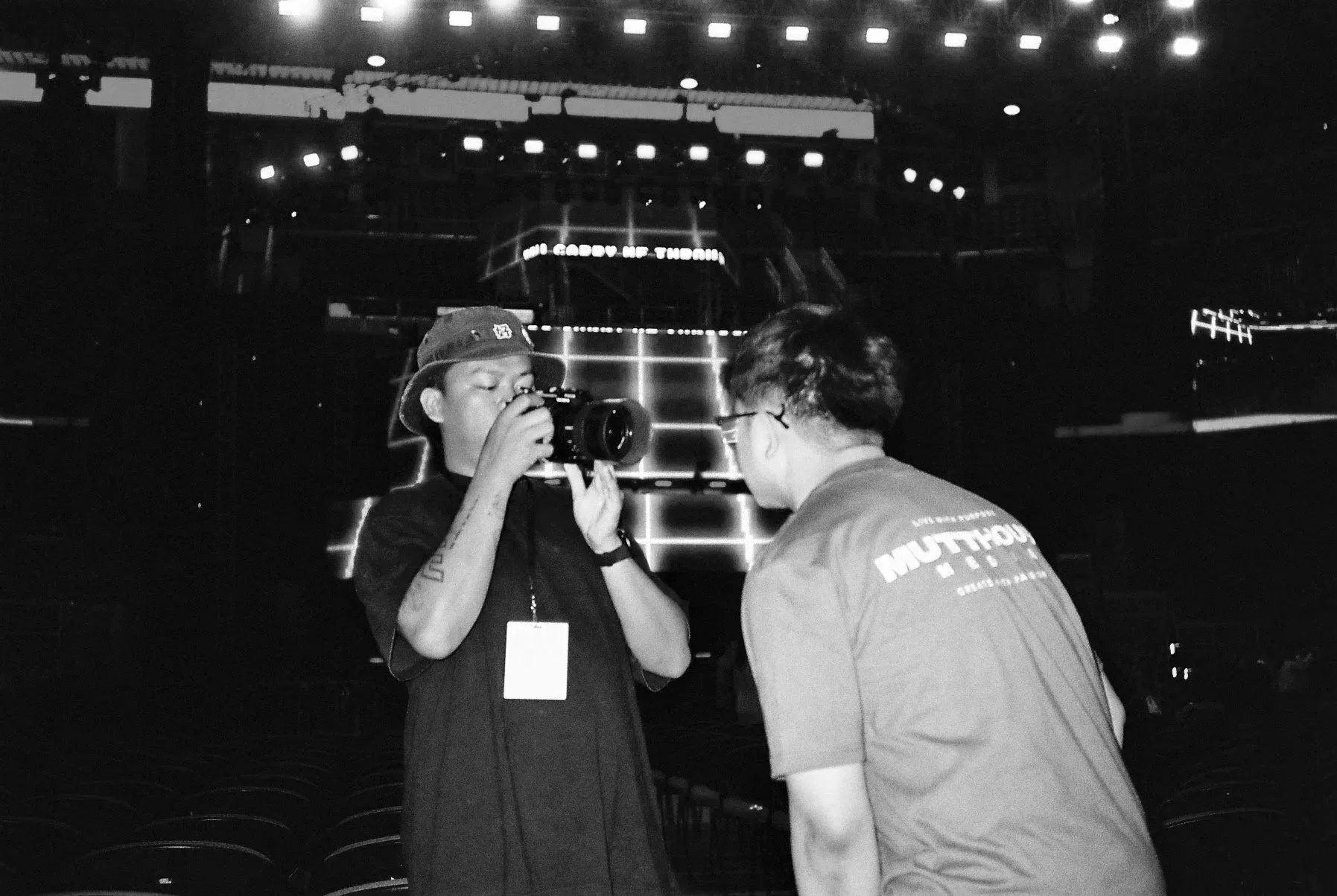 Behind the scenes of a film or television production set, with crew members working, filming equipment, and lighting in a large studio