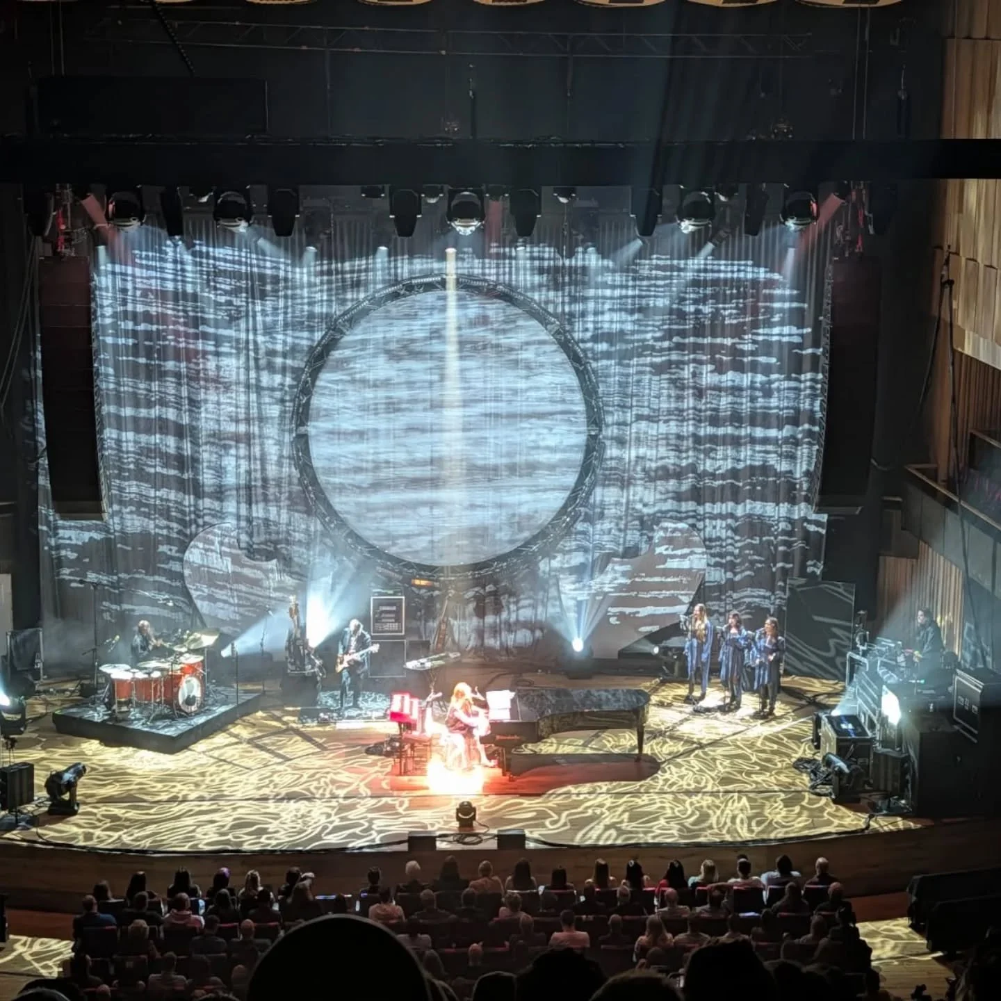 Tori Amos &ndash; In Times of Dragons Tour.

Custom dragon wing frames, wrapped in a crushed fabric scrim, a huge circular projection surface, and layers of crushed velvet behind, all built to work together and catch the light in completely different