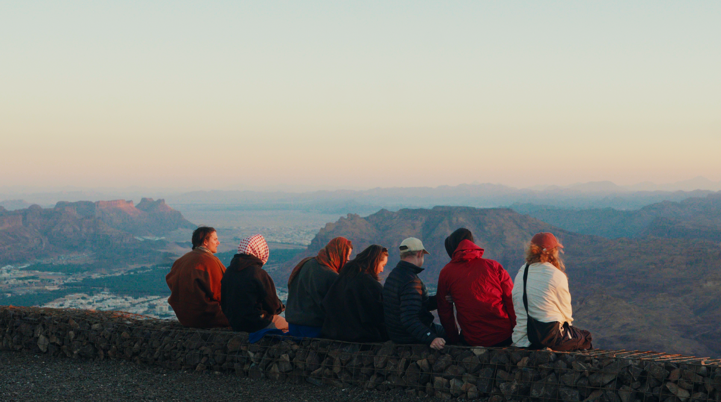 Cyclists watching out from the AlUla skyview at sunset