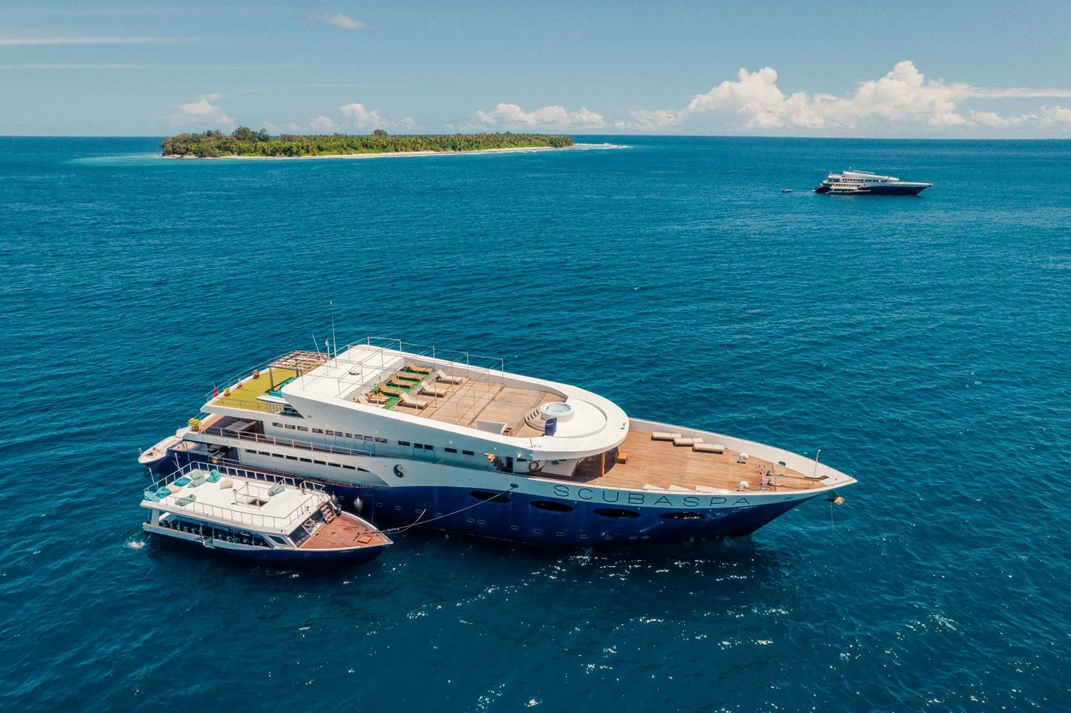 Luxury Maldives liveaboard yacht cruising over clear blue water