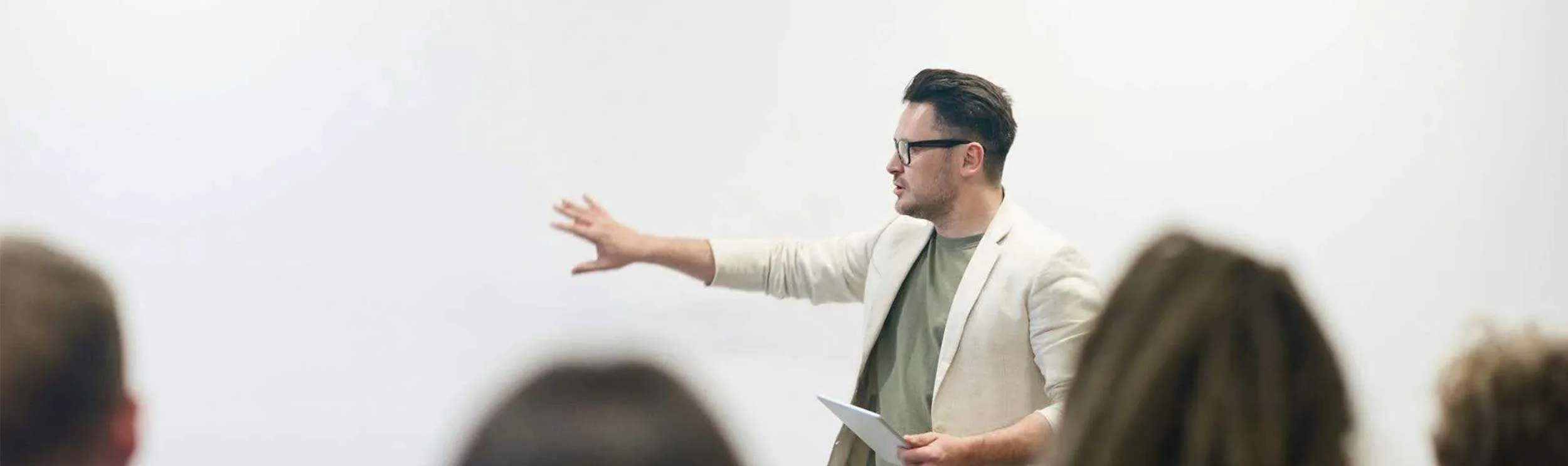 A man stands before an audience, sharing information during a professional presentation.