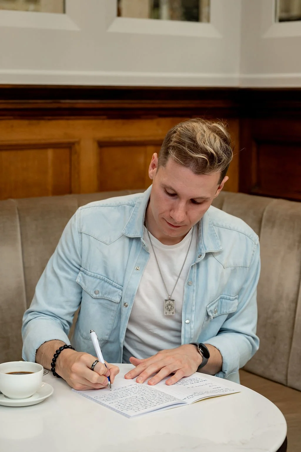 Liam Marshall, judge of Just Write! monthly creative writing competition, writing in a notebook.