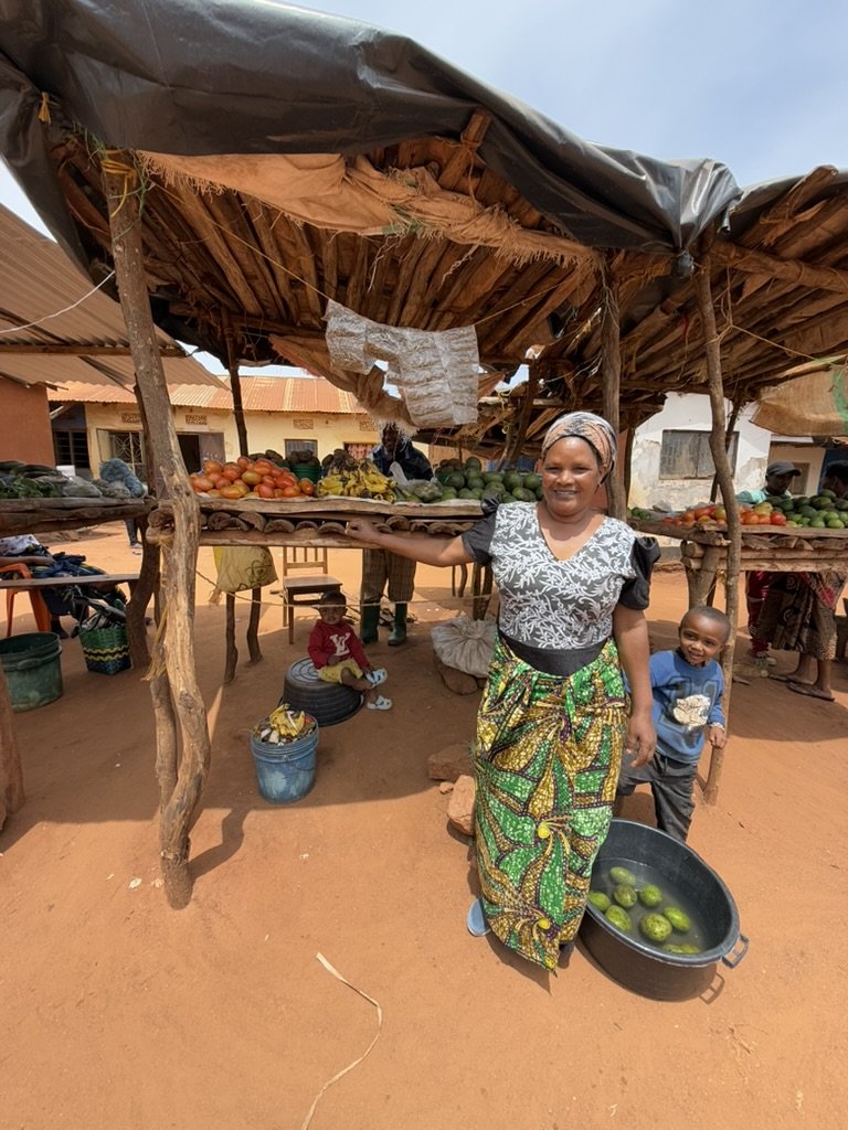 Naimee selling vegetables and small fish (an East African food staple) at her outdoor stall