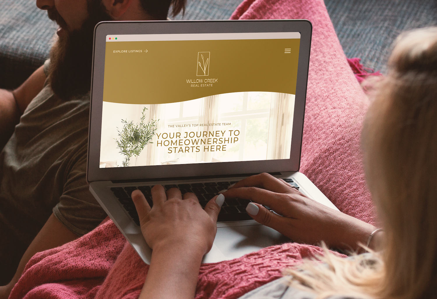 Person using a laptop displaying a real estate website with the text 'Your Journey to Homeownership Starts Here' and the logo 'Willow Creek Real Estate.'