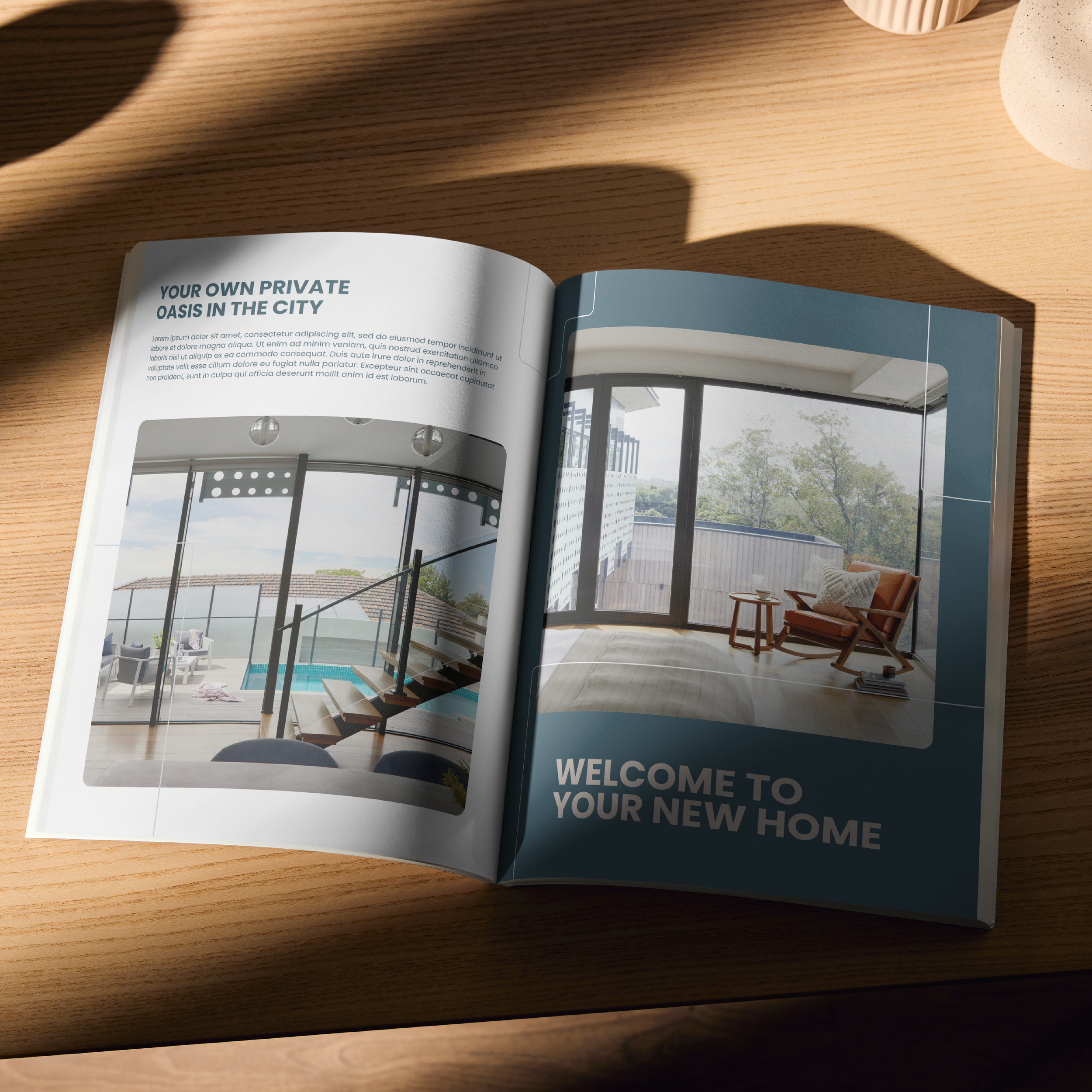 Open magazine on a wooden table featuring images of modern interiors with large glass windows and outdoor views. Headings read 'Your Own Private Oasis in the City' and 'Welcome to Your New Home.'
