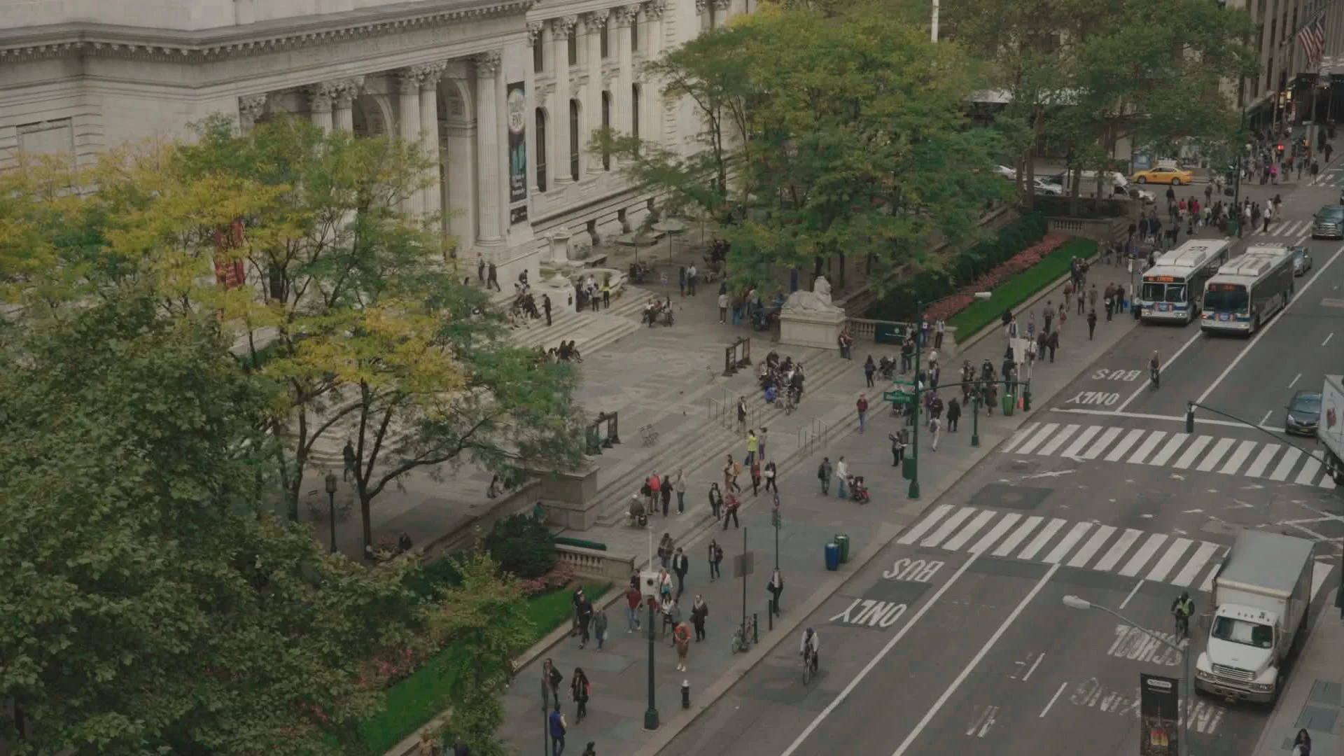 Aerial view of the New York Public Library, with people and traffic on the street in front.