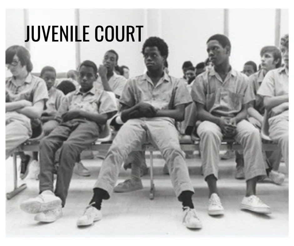 Black and white photo of young men sitting in a juvenile court waiting room.