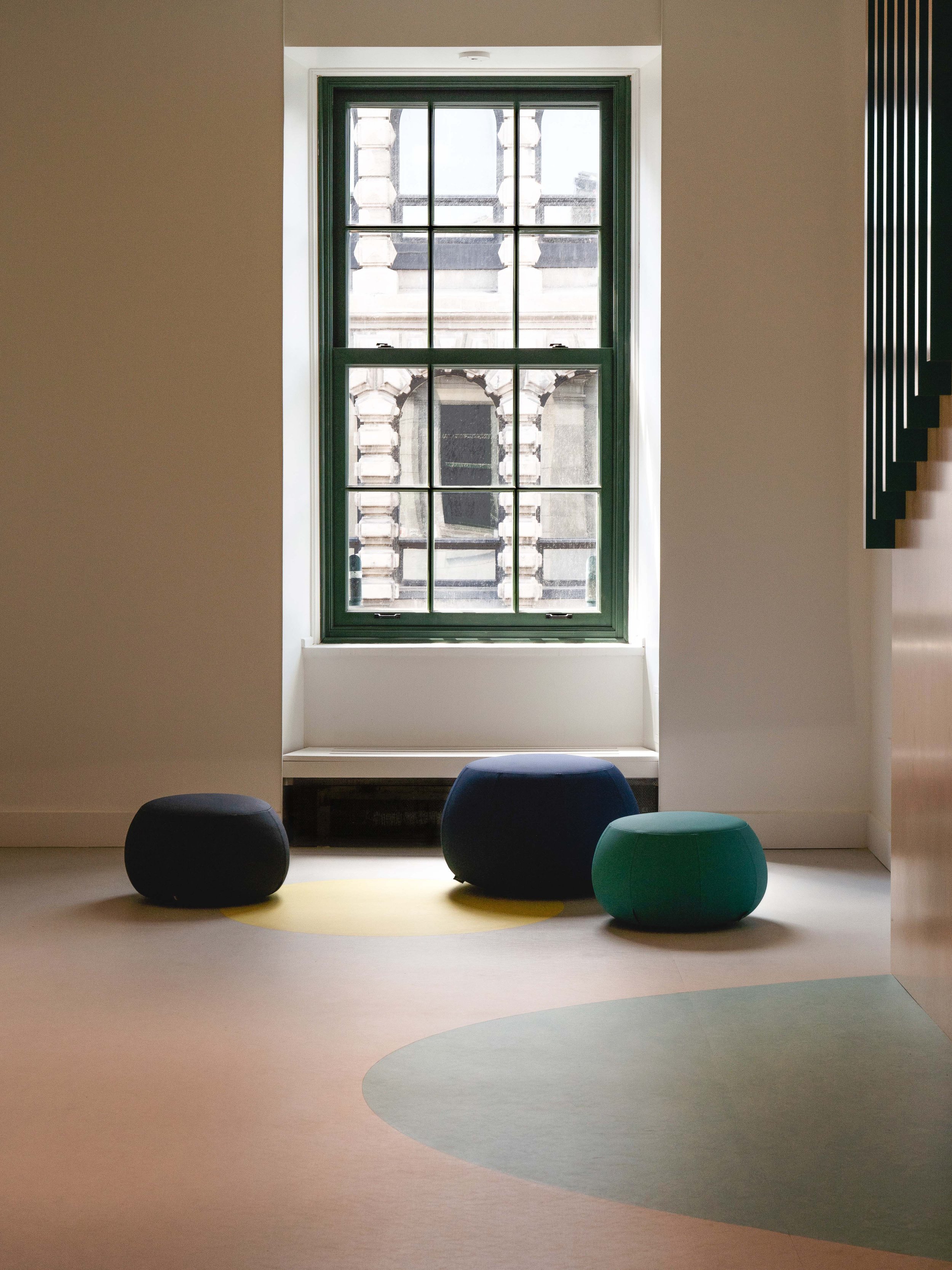 Aménagment de l'espace d'accueil et lounge, là ou les enfants arrivent. La mural dans l'escalier se poursuit au sol en vagues. La fenêtre à carreaux et le design contemporain et ludique parlent de deux époques. Design par inscape le studio