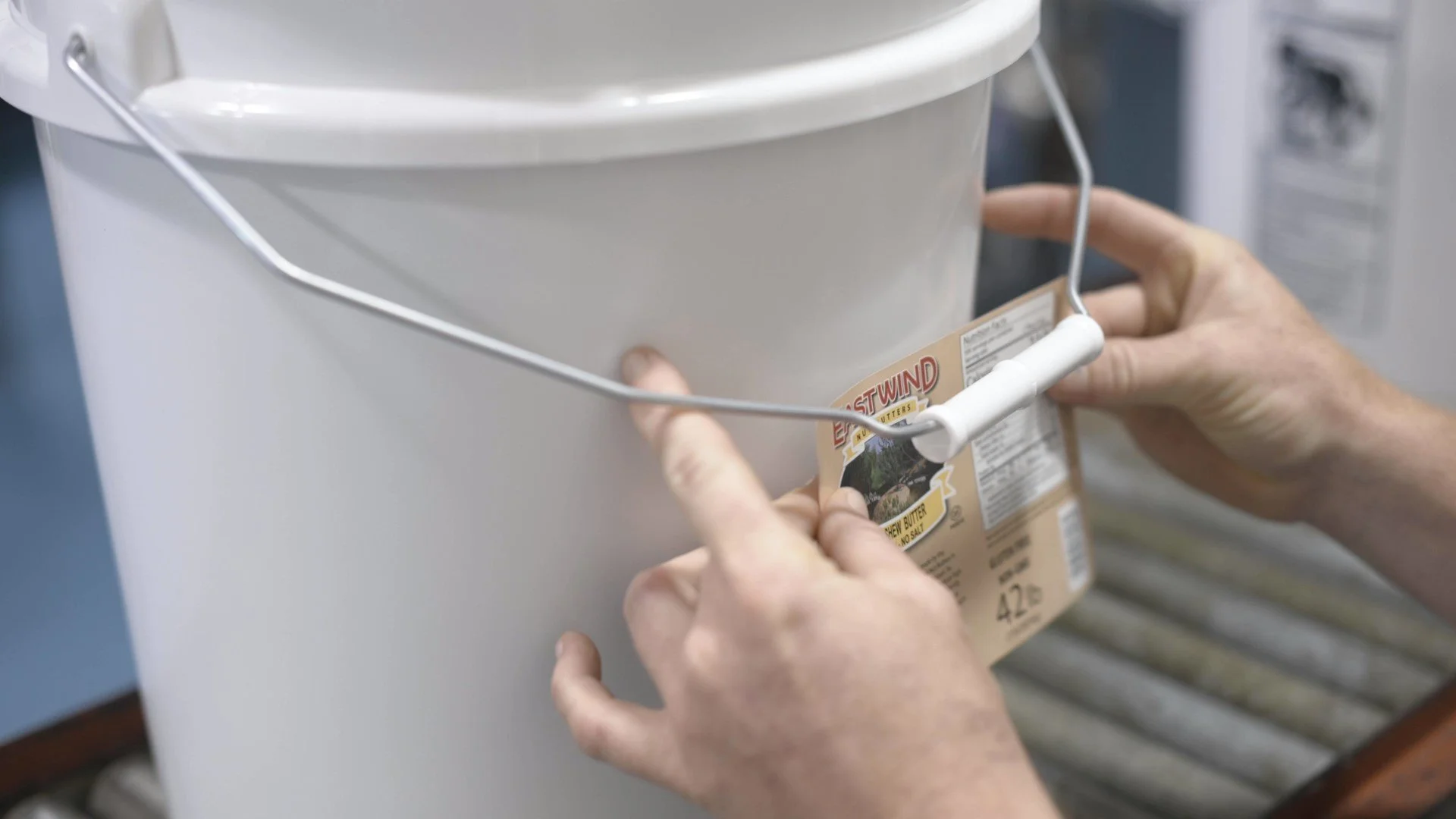 A 42.lb tub of raw cashew butter being labeled at East Wind Nut Butters