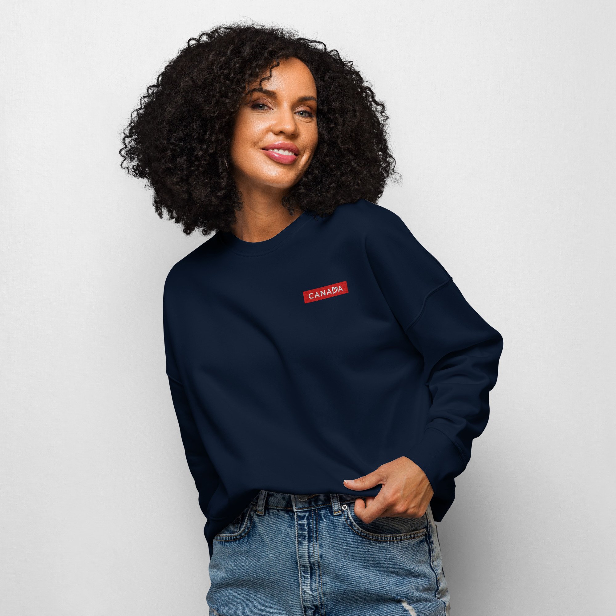 Model wearing sweater with an embroidered Canada logo on the left chest