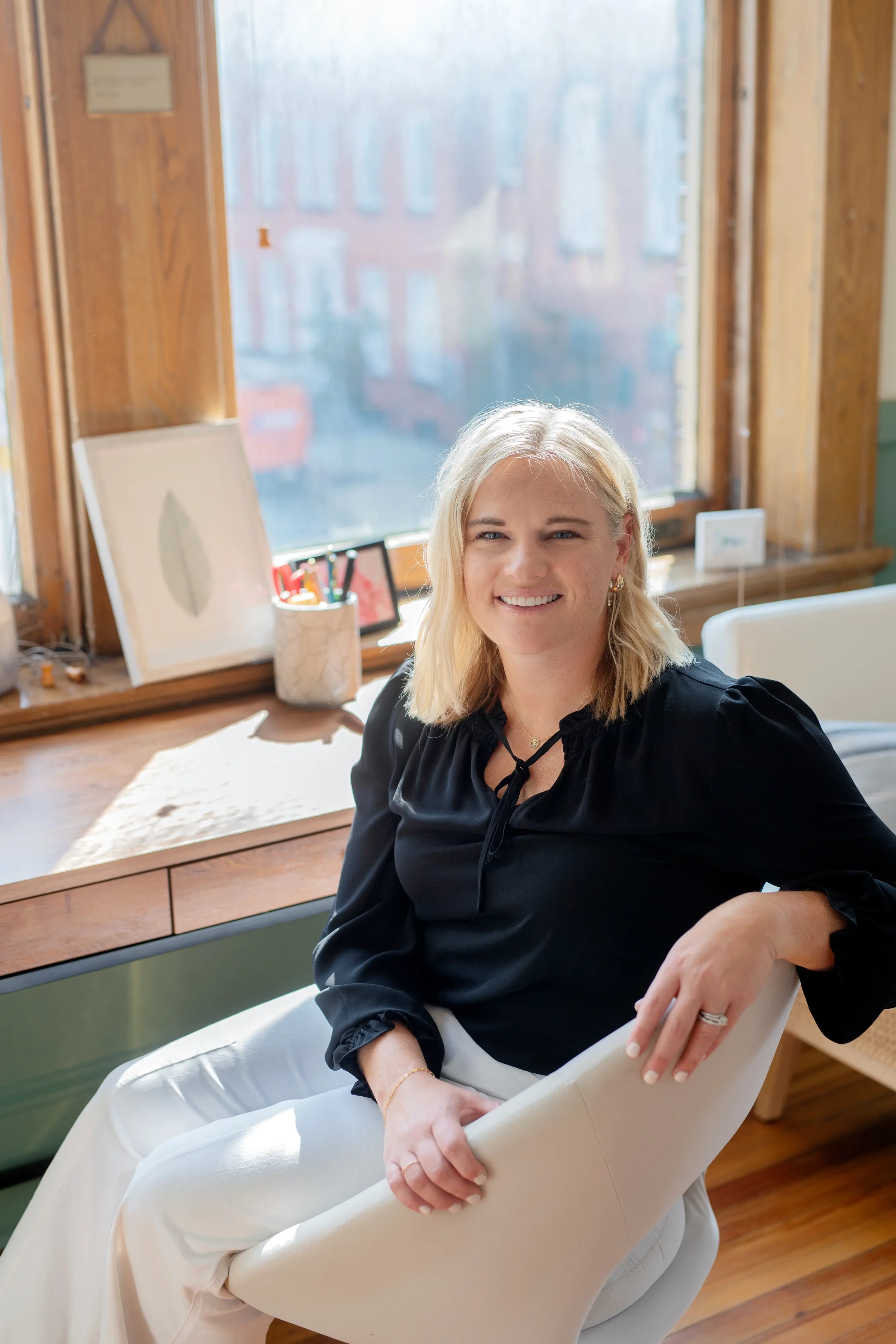 Liz Bohan. LCPC looking at the camera smiling from her virtual office serving female professionals experiencing burnout in Washington, DC